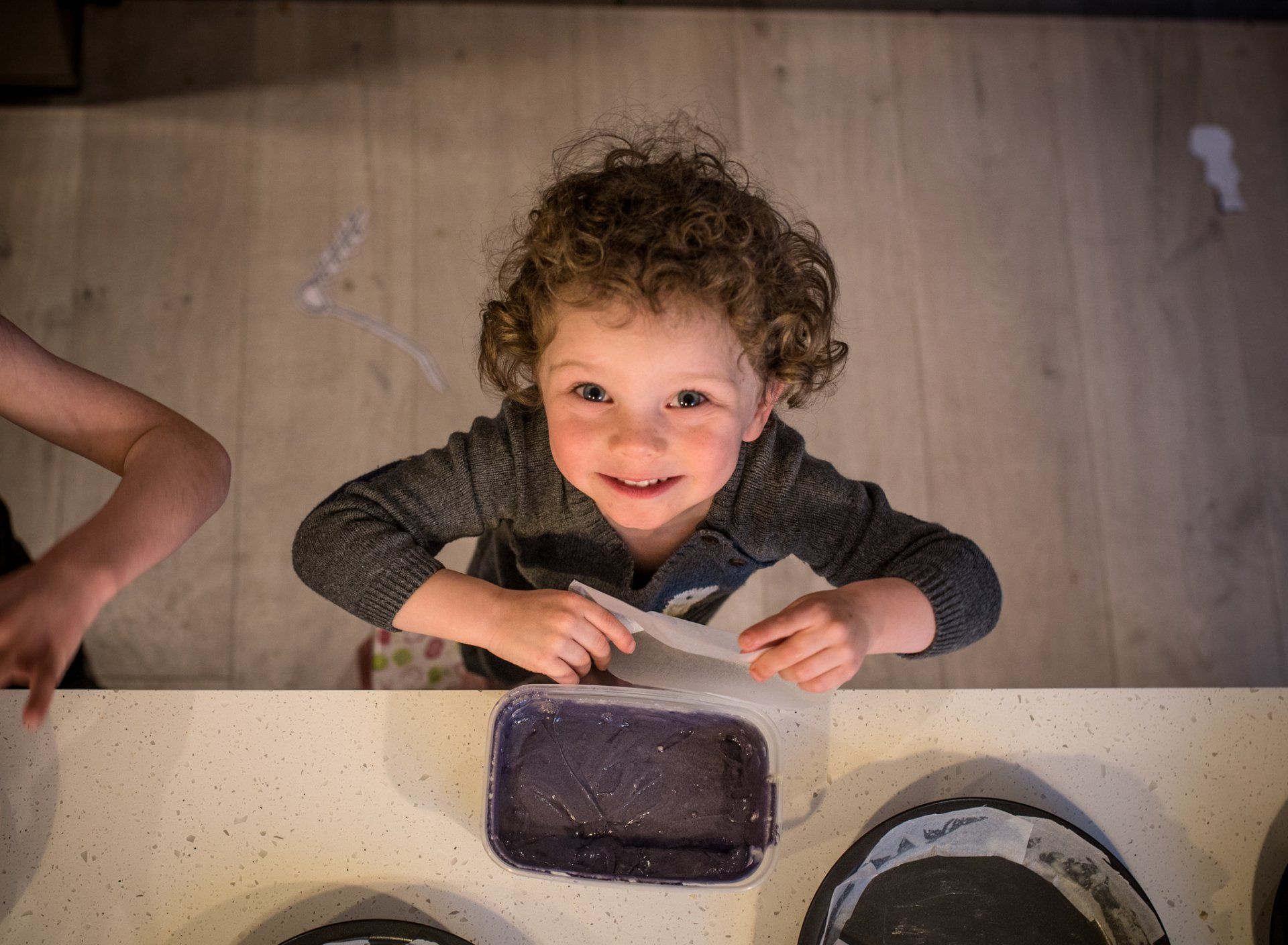 toddler baking a cake lining a tin with parchment paper