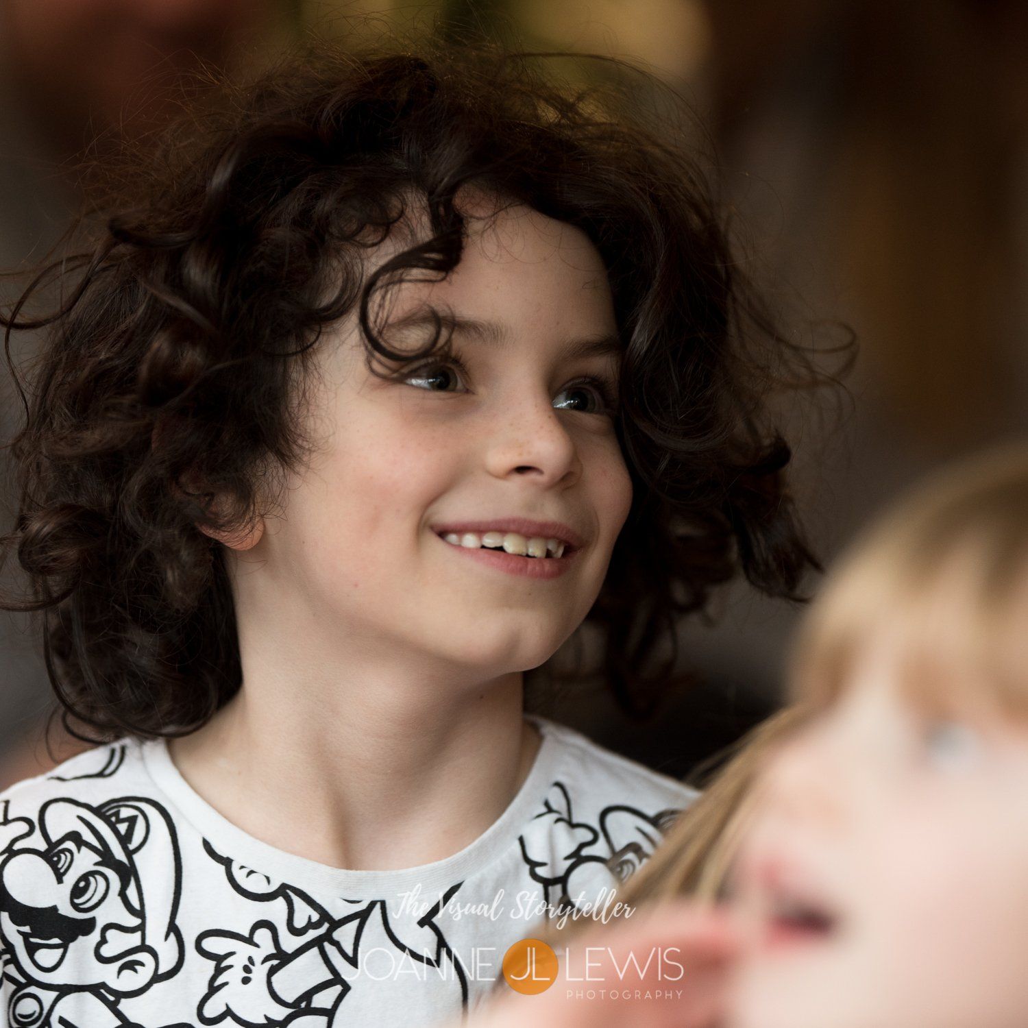 Beautiful young boy with dark curly hair smiling