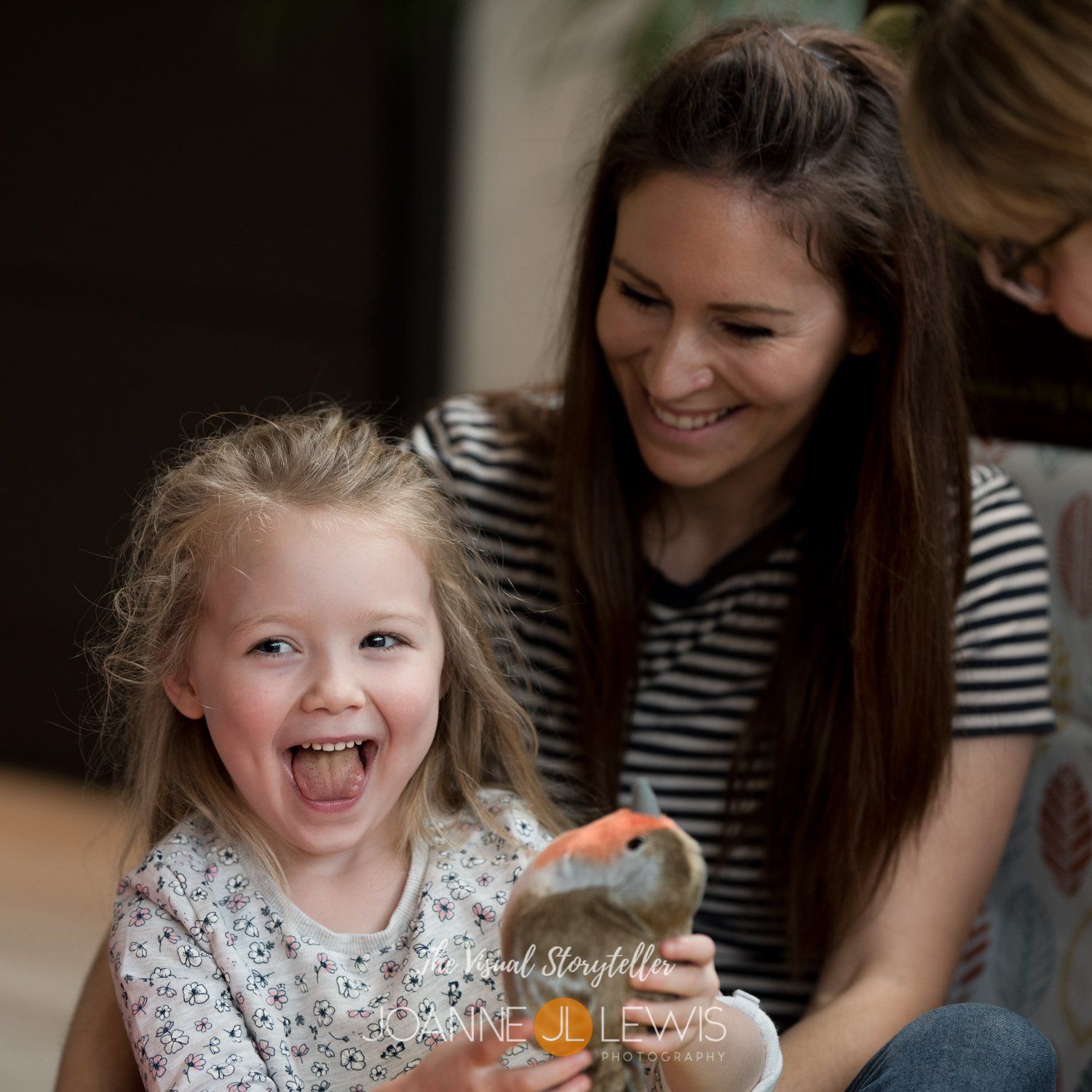 Young girl laughing on her mothers lap
