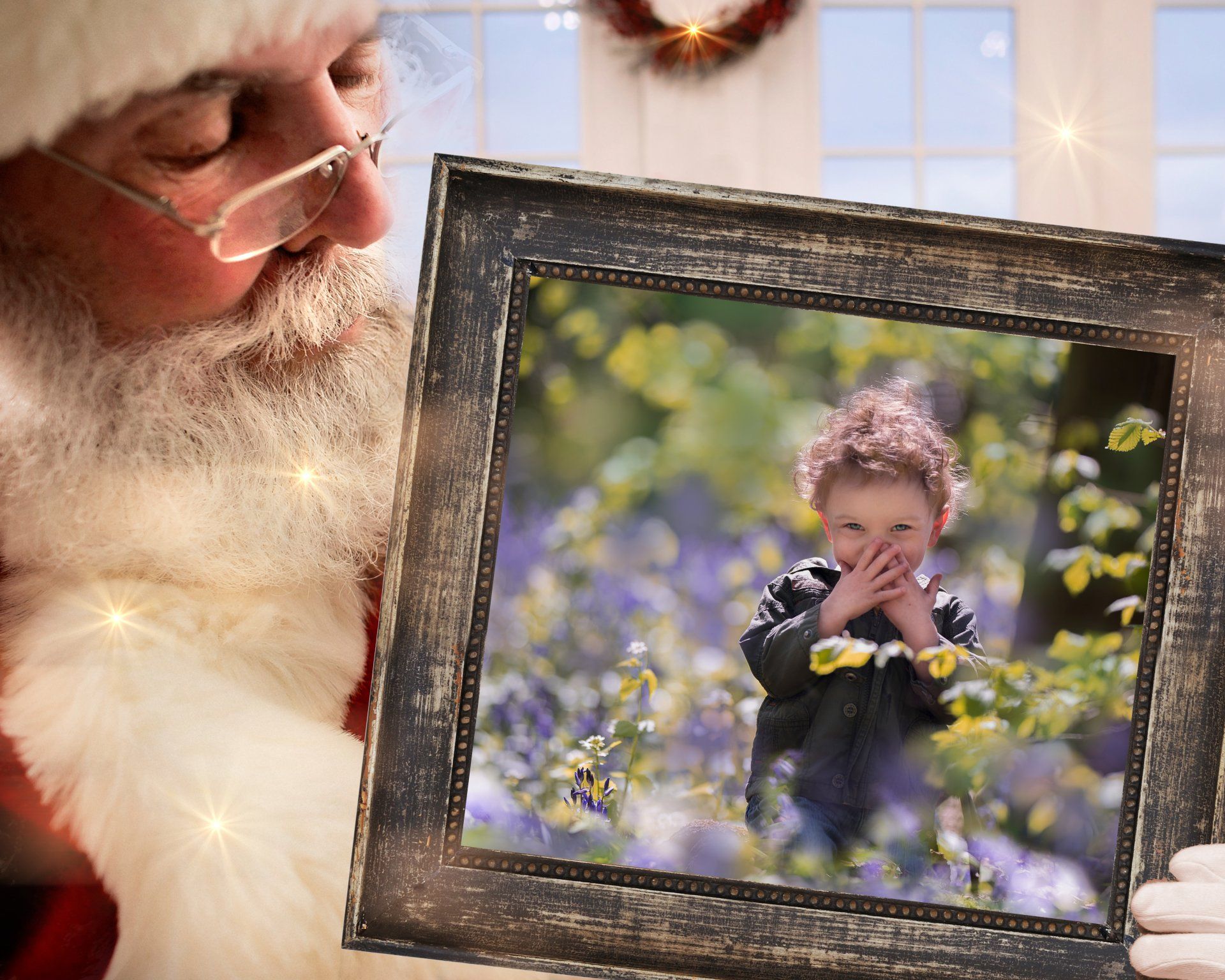 Santa holding a framed picture of little boy in the bluebells