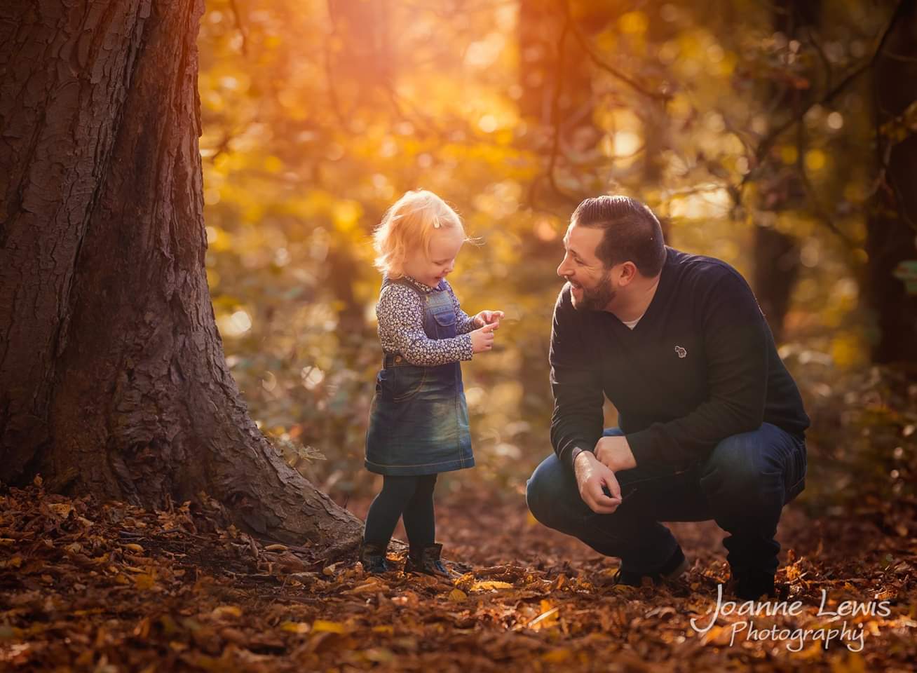 Father and daughter lit by sunlight in the forest