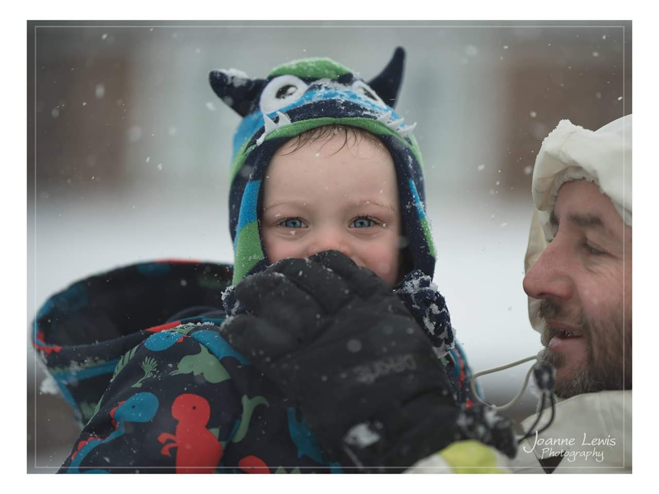 Boy having snowball wiped off of his face by his dad