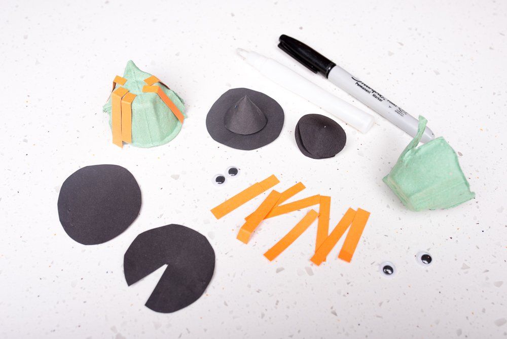 Pieces of coloured card, egg boxes and google eyes to make a witches head