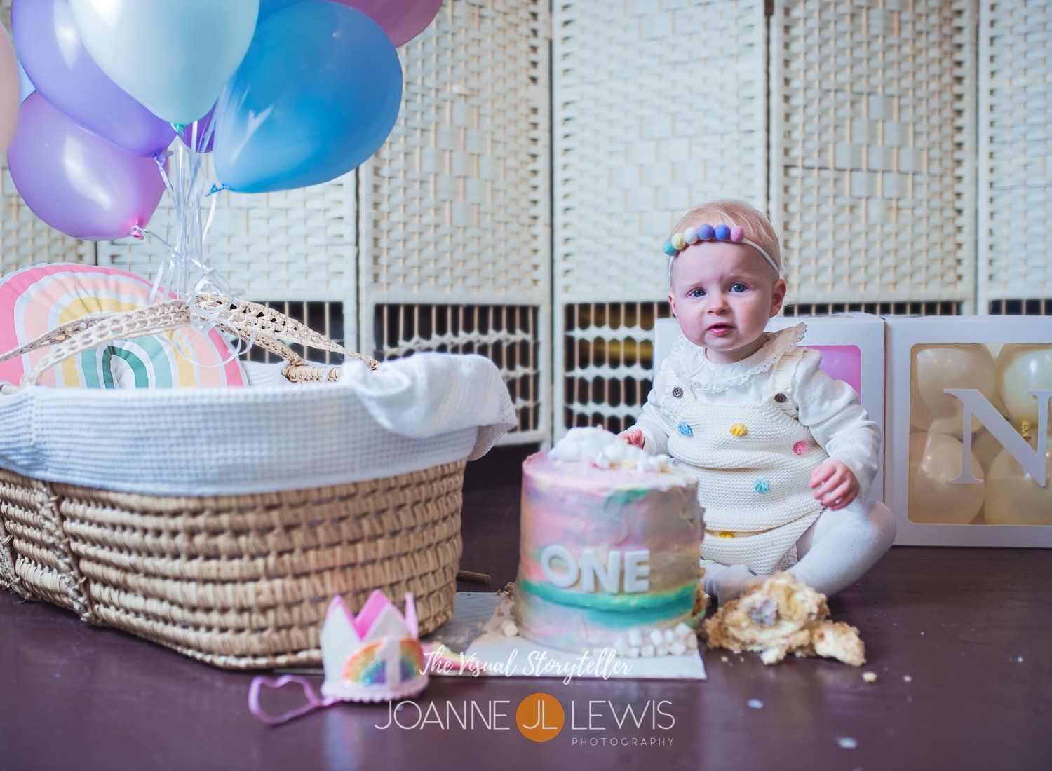 Cake smash photography of first birthday with rainbow theme and balloons in Harlow Essex