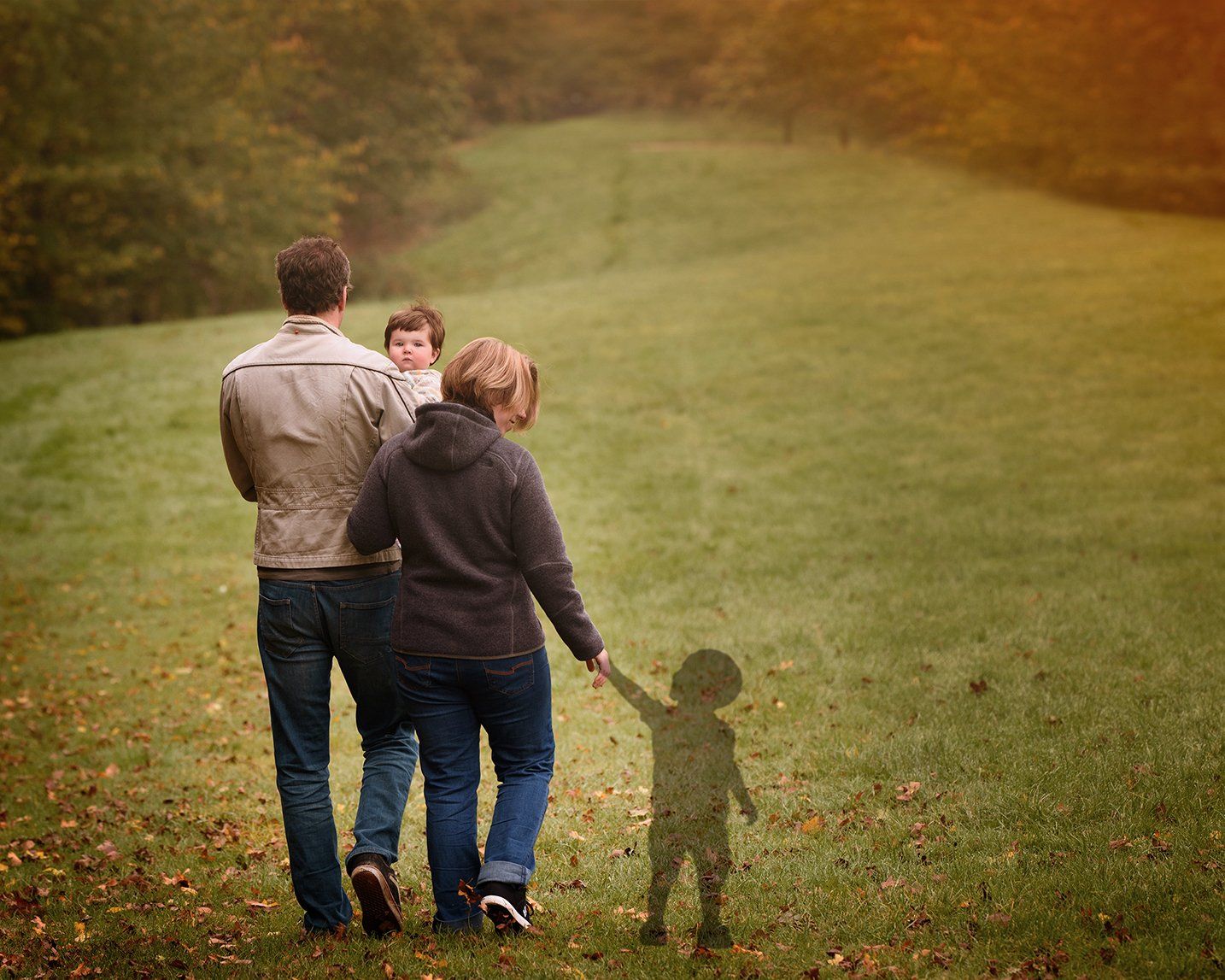 Family walking in a park in Ware with their Rainbow daughter and a shadow of the son who died