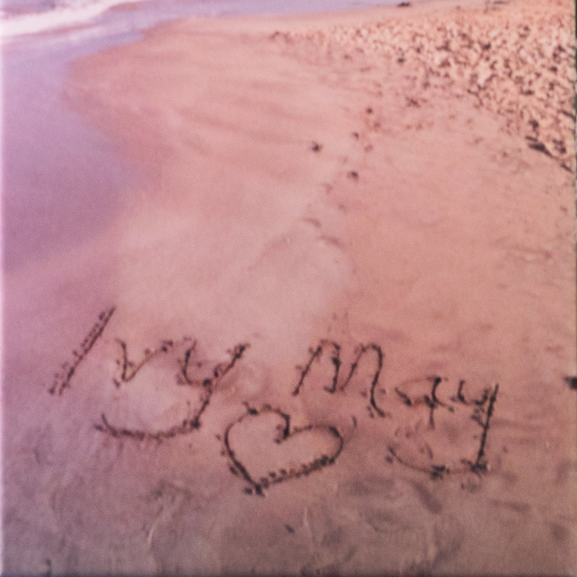 Ivy May written in the sand at the beach