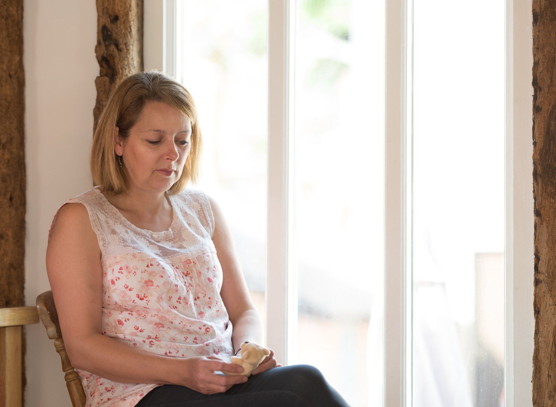 Heather sitting at window with Flynn's teddy