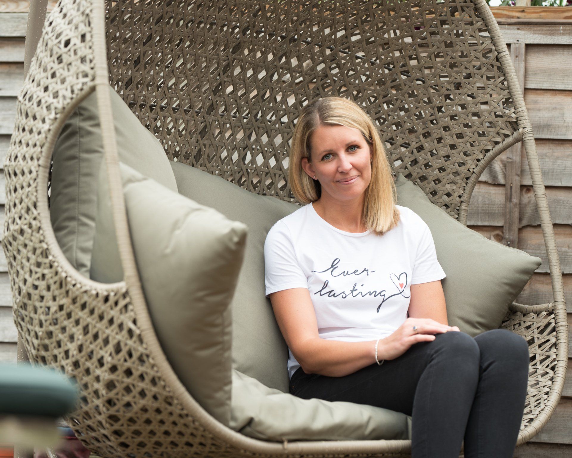 Mum sitting on a garden swing showing her ring made with ashes