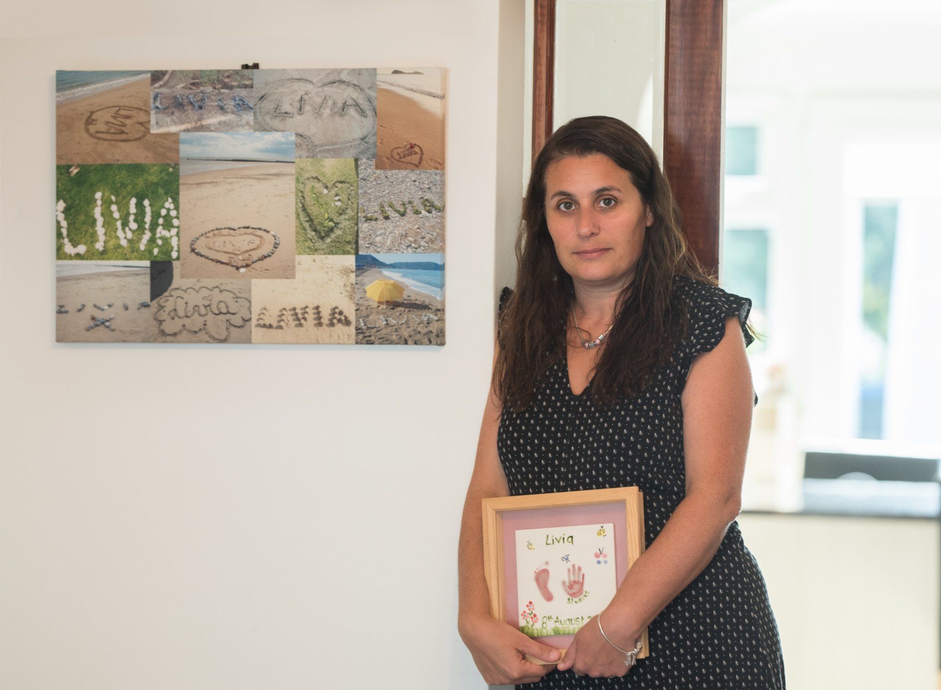 Gigliola holding lives hand and footprints cast in front of her Livia photo