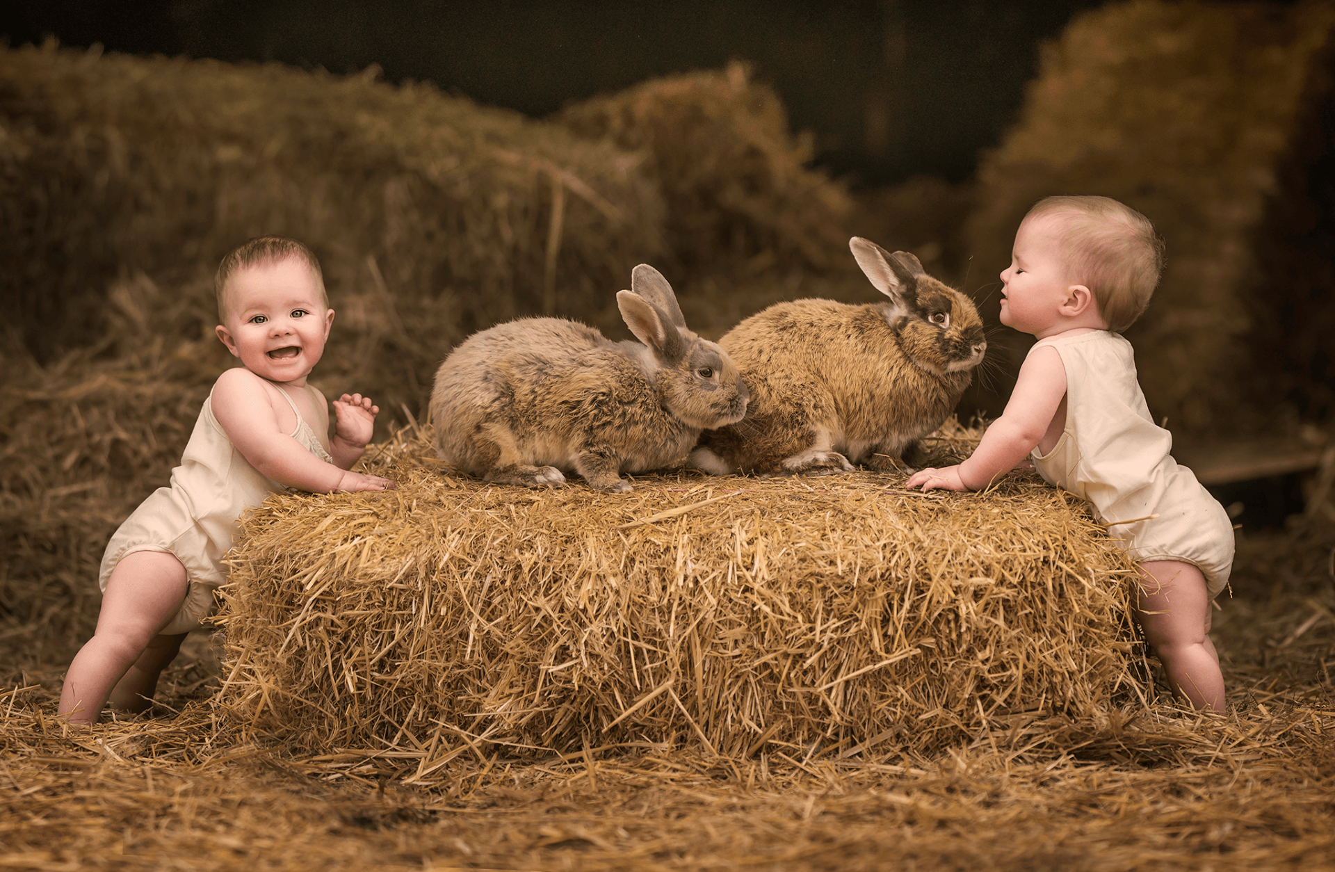 Twin girls and bunnies in Hertfordshire farm with hay bales for sitter photo session
