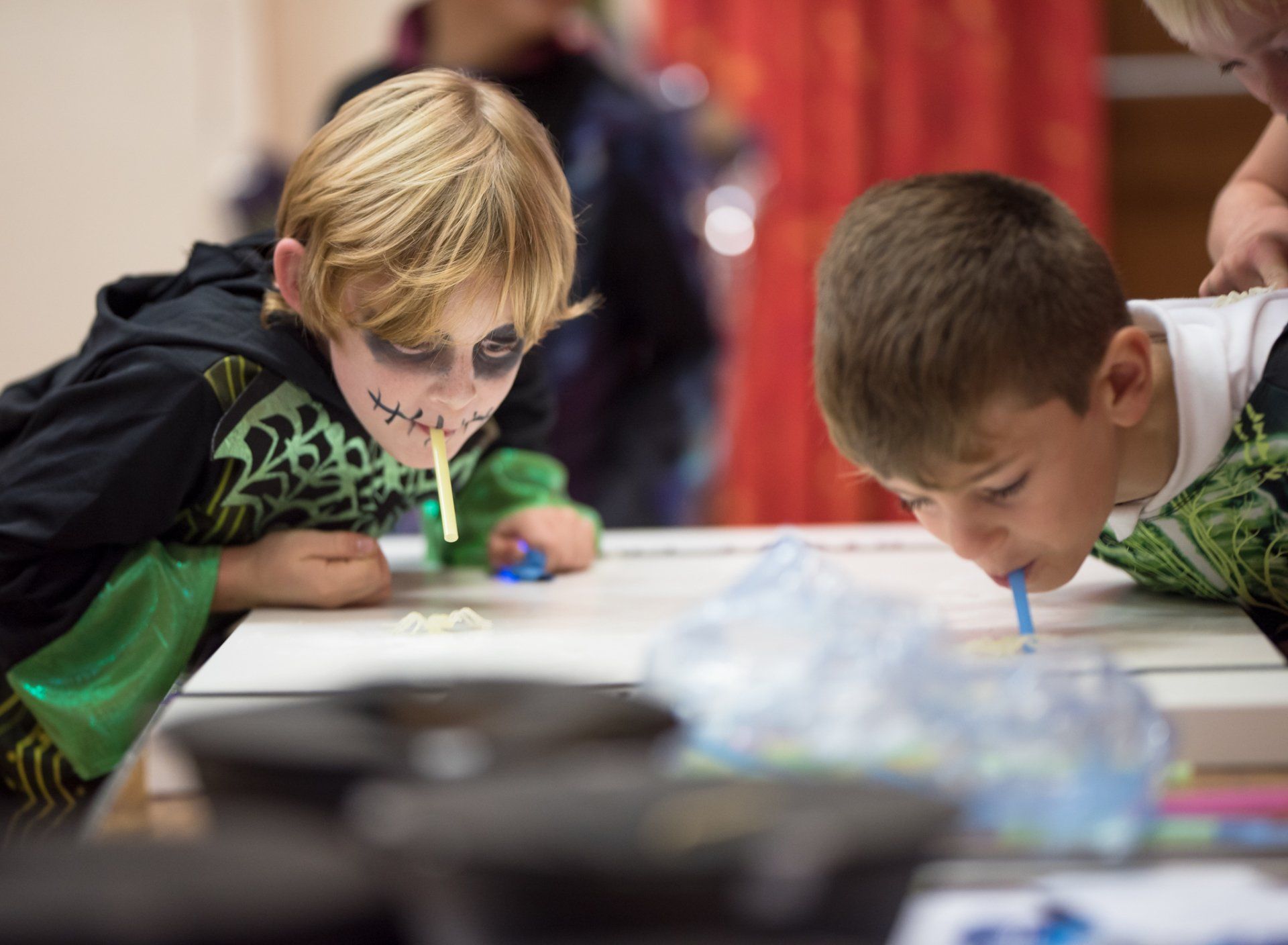 boys playing Halloween games with straws