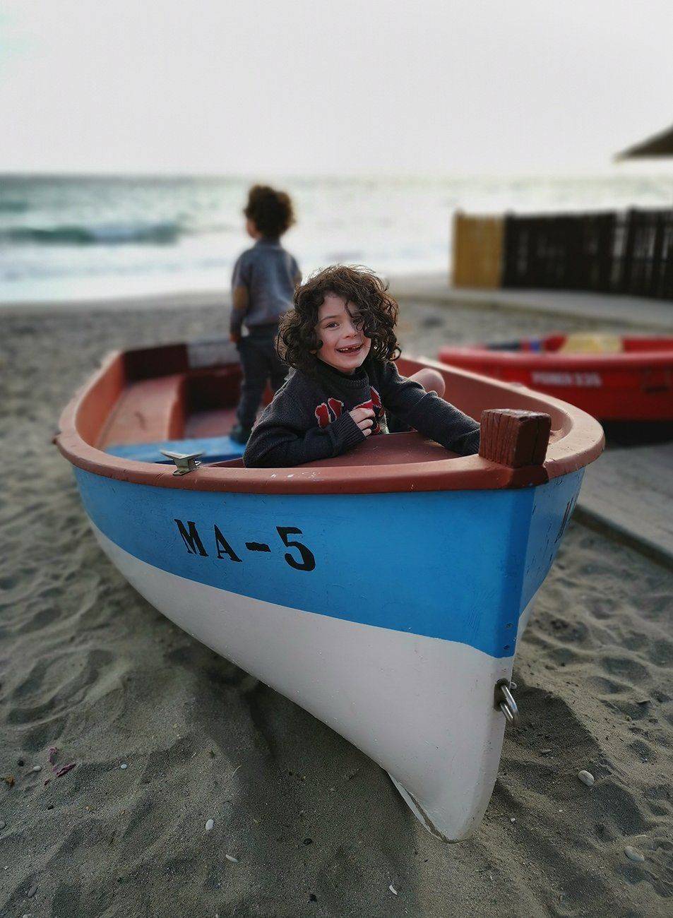 Ahoy sailor - boys sitting on a boat on the beach in Spain