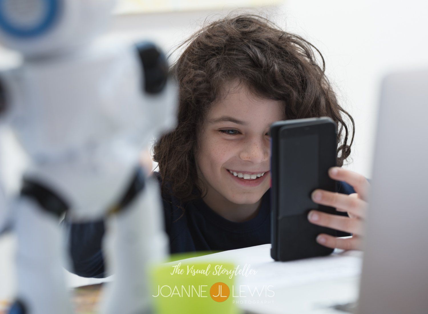 Young boy with dark curly hair talking to a friend on video call