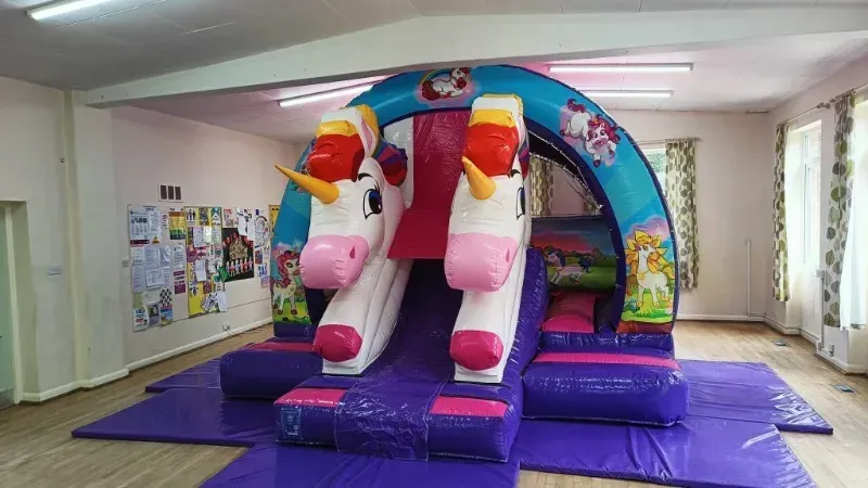 3D Unicorn Curved Slide Bouncy Castle from Bury Soft Play
