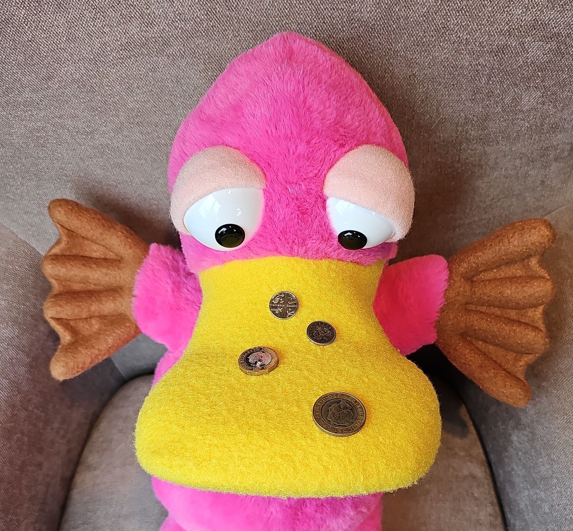 Theo the Pink platypus puppet has four different coins on his beak.