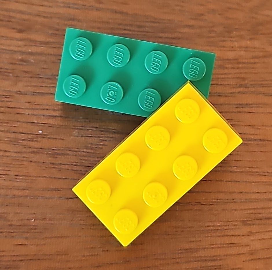 Two lego bricks. One green and one yellow.