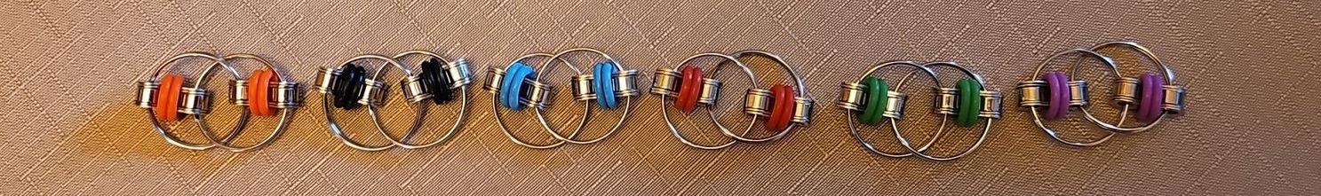 A row of different coloured Fidget toys that continuously flip as you turn them over in you hand