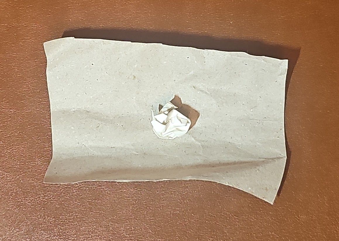 The screwed up ball of paper on top of what will become a sweep wrapper