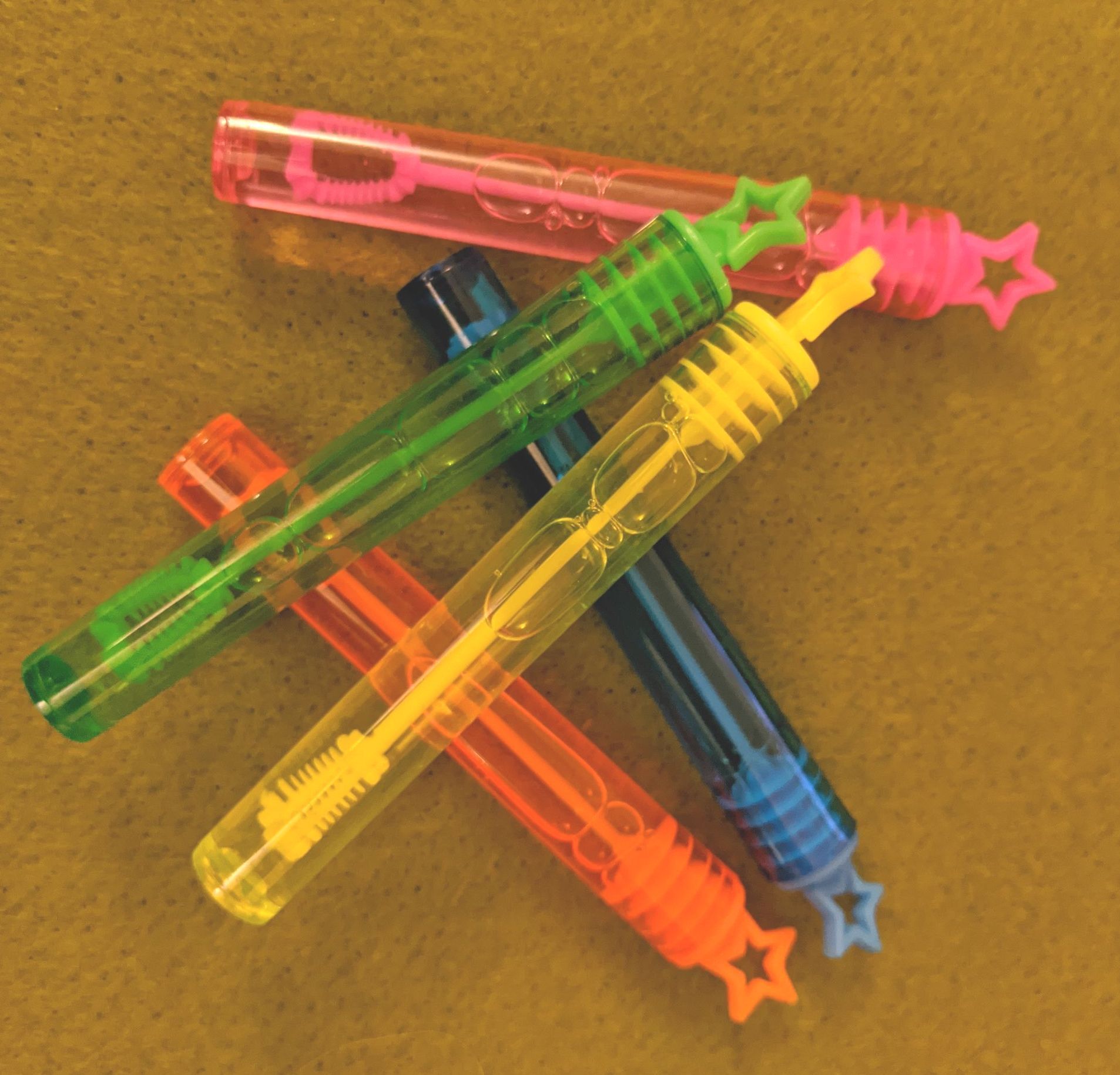 five tubes of bubble liquid with a bubble wand inside.