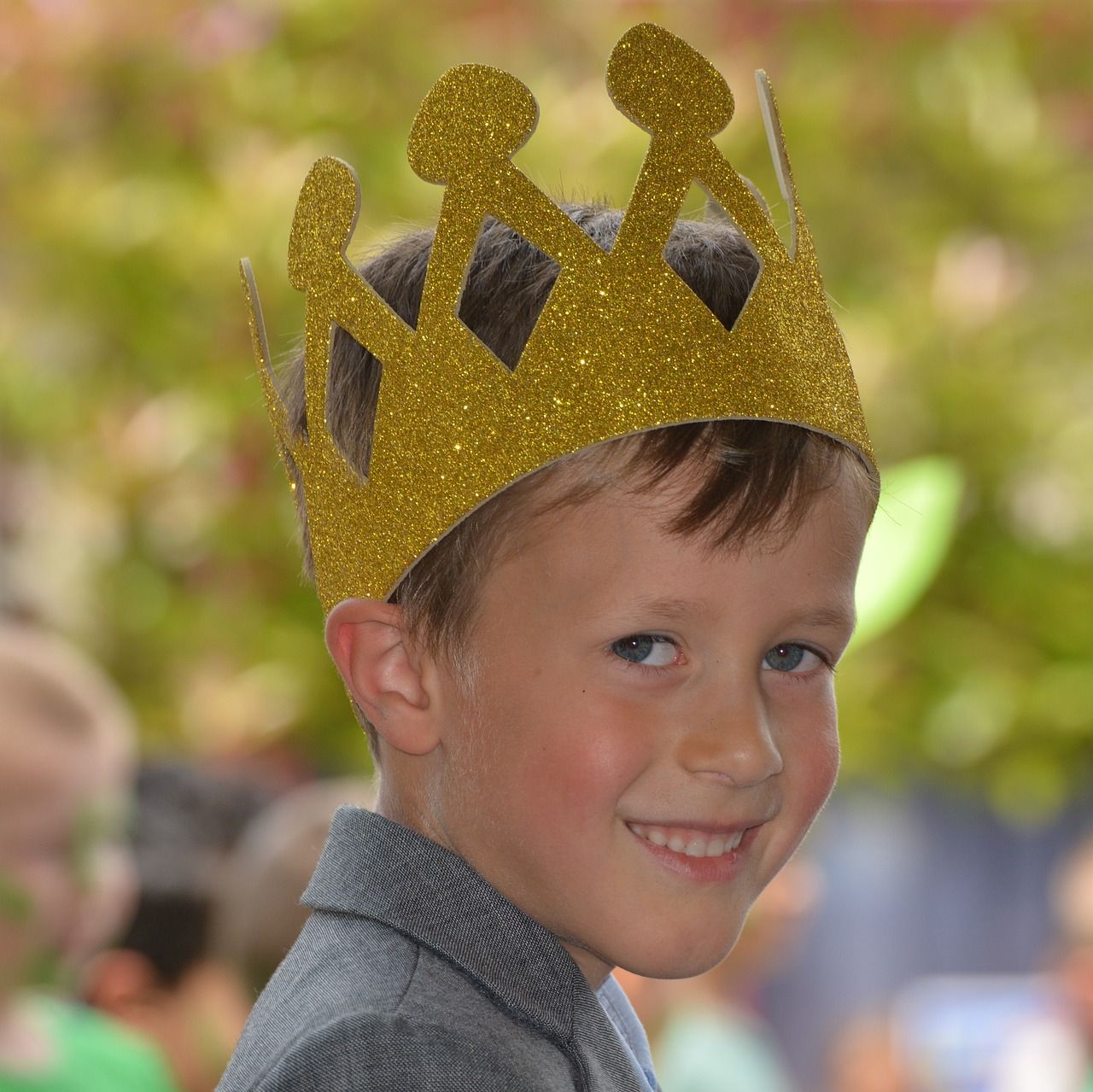 A child wearing a glittering gold cardboard crown.
