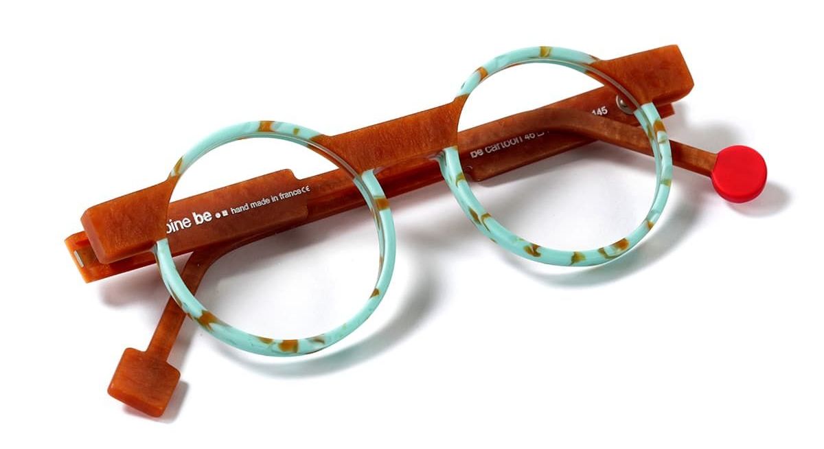 A pair of funky glasses. The lens parts are round, blue/green with brown flecks, the rest of the frame is the colour of the brown flecks.