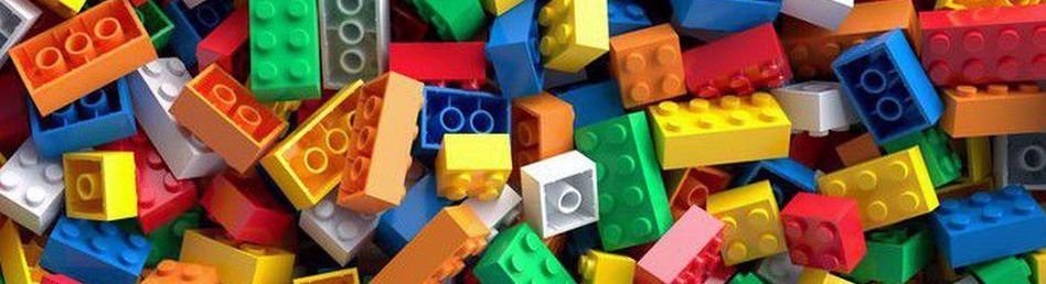 Lots of lego bricks in many colours, dropped into a messy pile.