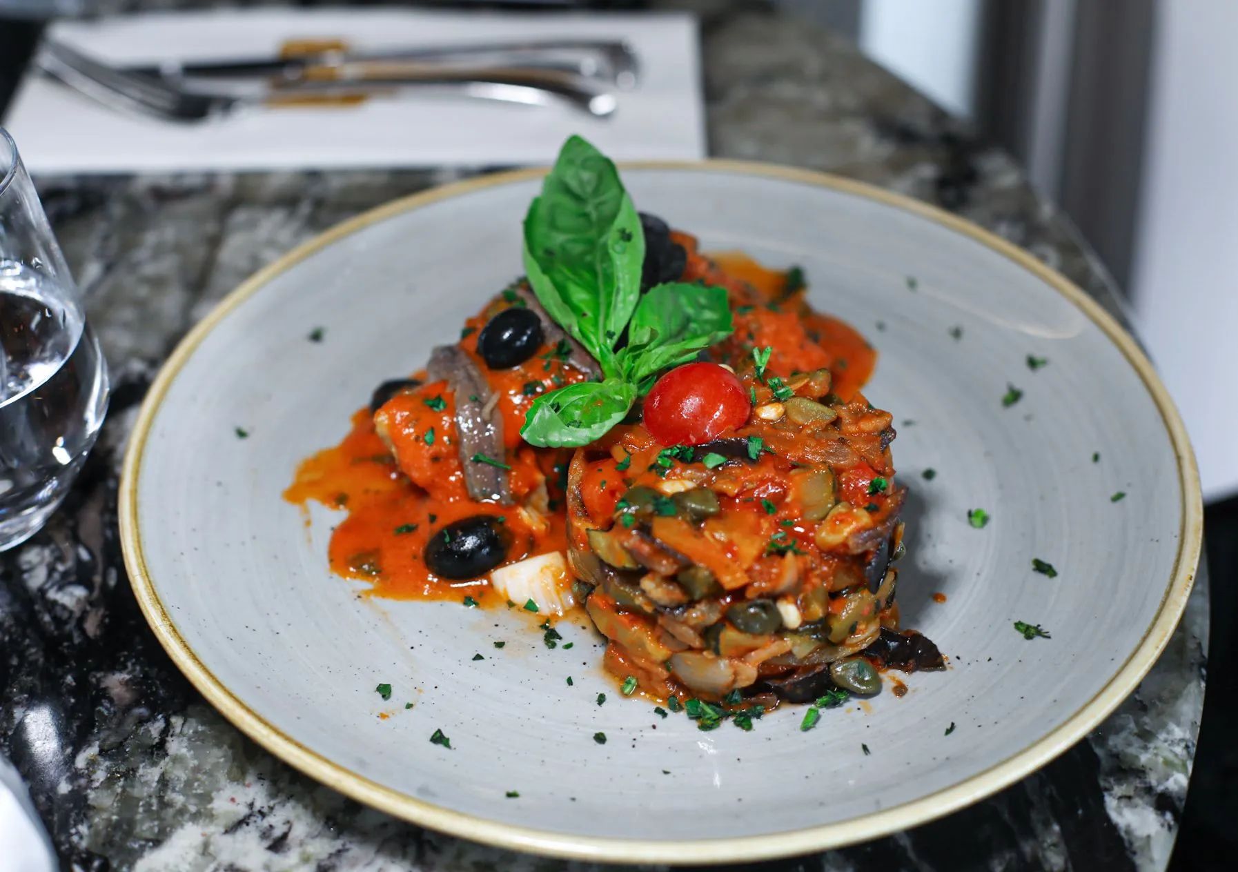 Cabillaud alla puttanesca e caponata dressé à l'assiette