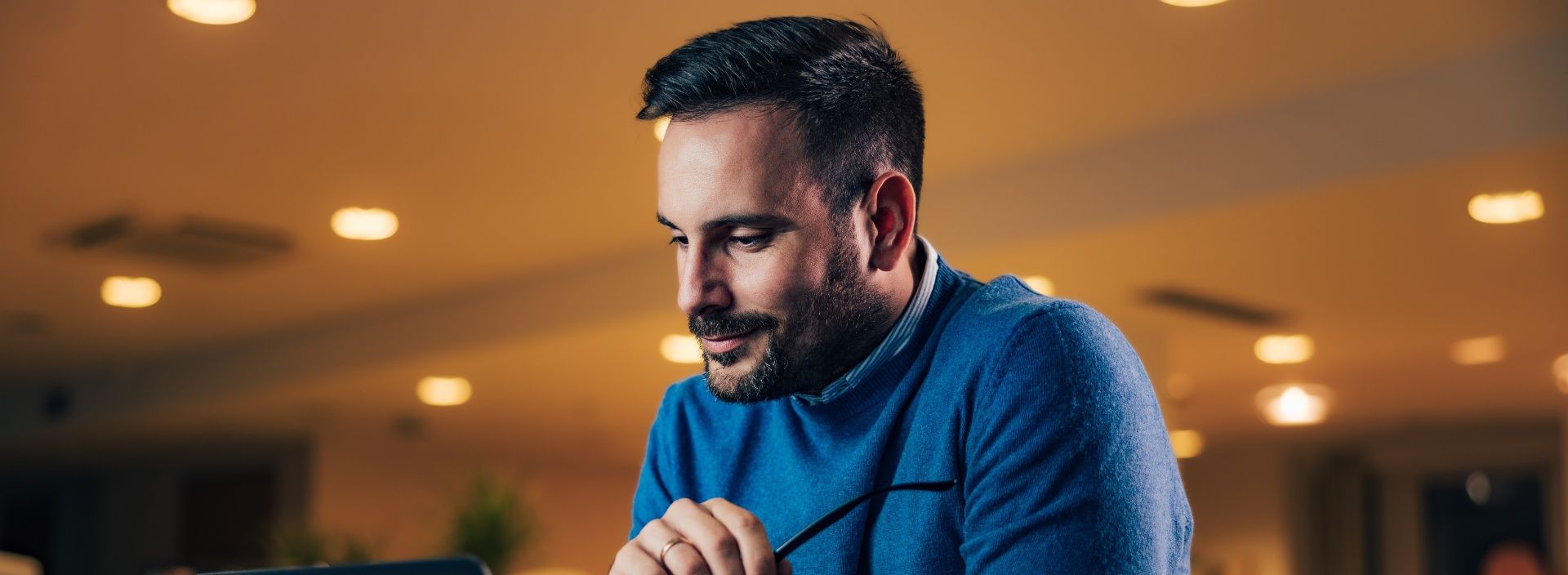 Mann in blauem Pullover auf der Jobsuche