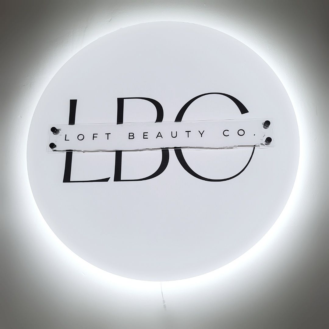 A backlit round wooden sign for a salon