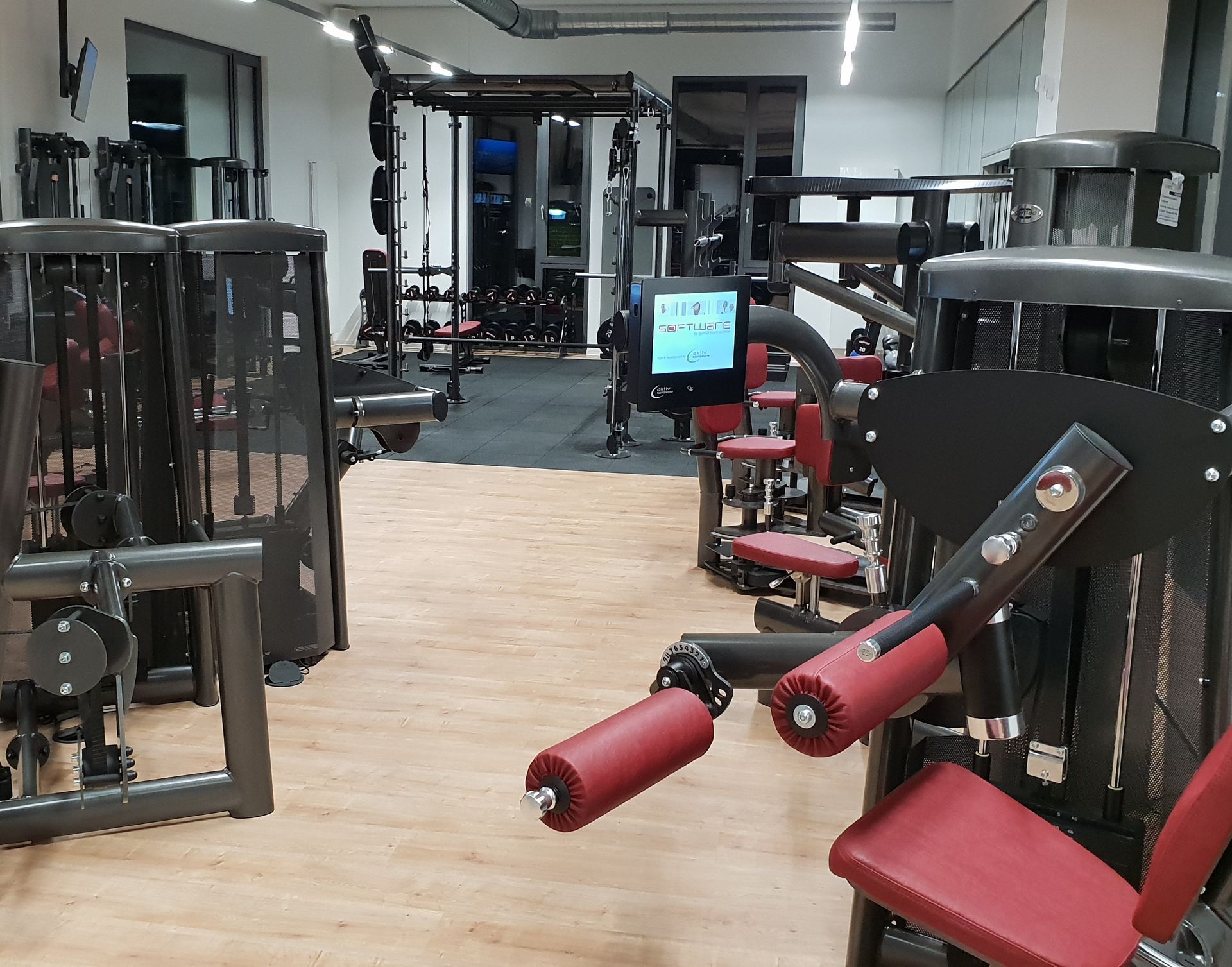 Fitnessraum mit modernen Kraftgeräten und Trainingsbereich.