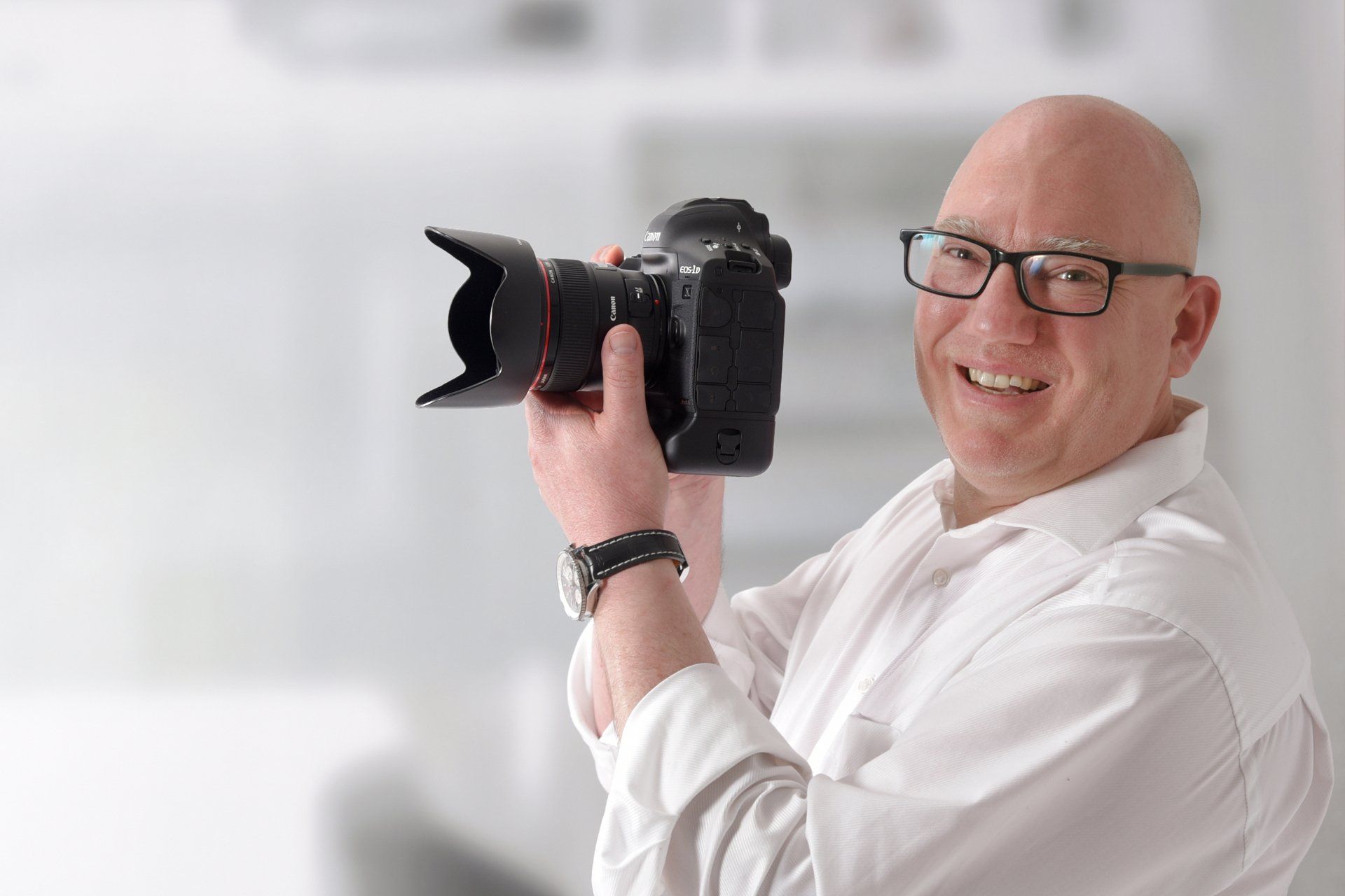 Der FOTOKURS NÜRNBERG Fototrainer Alexander Mrosek lächelt den Bildbetrachter entgegen.