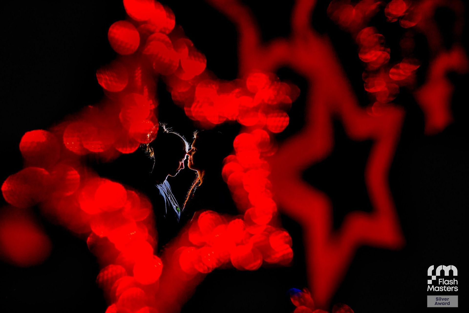 flash masters silver award andrea kuehl lichtsilhouette von 2 mädchen umrandet mit rot leuchtenden sternen