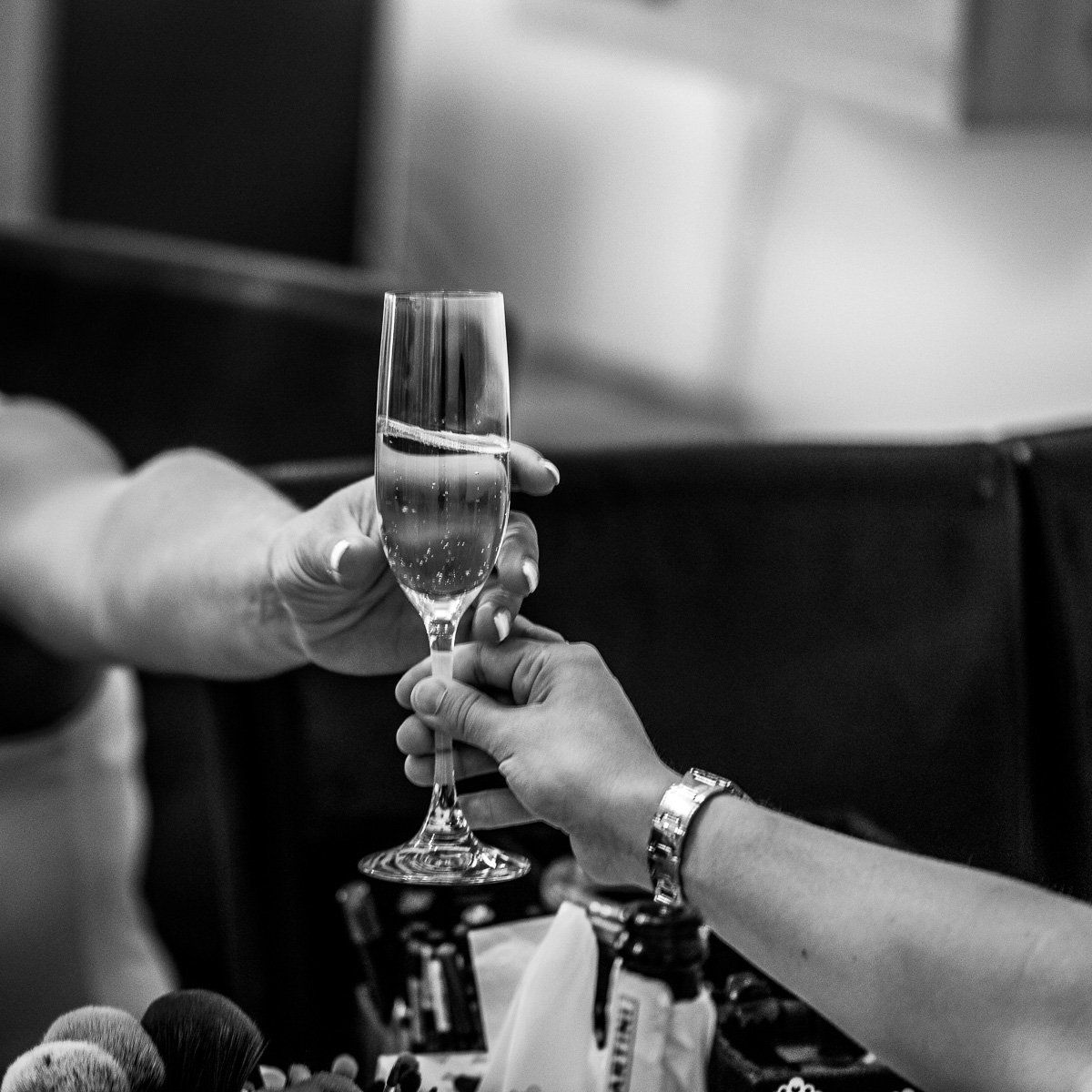 2 hände reichen sich ein sektglas zu