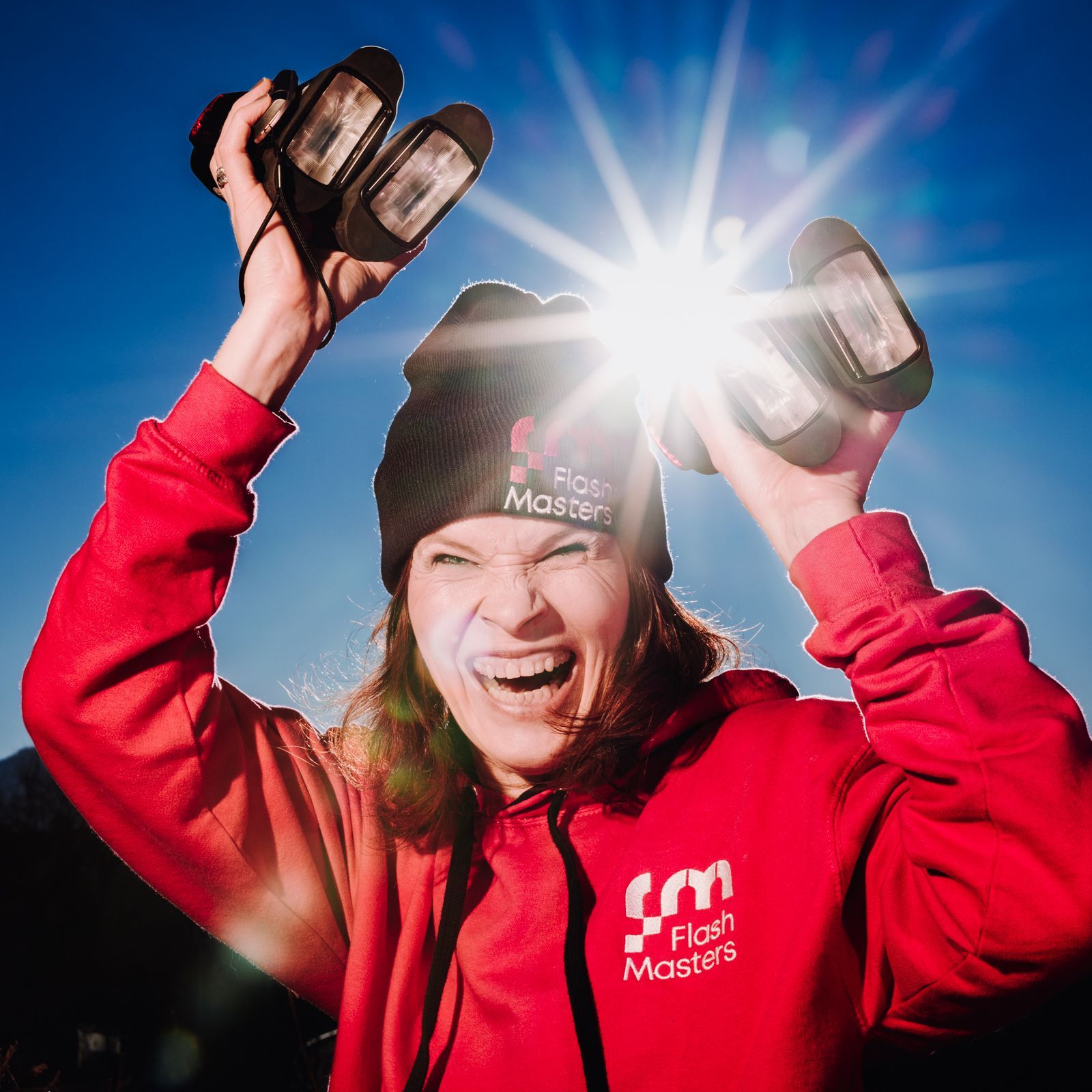 fotografin mit blitzen in der hand vor blendenstern der sonne