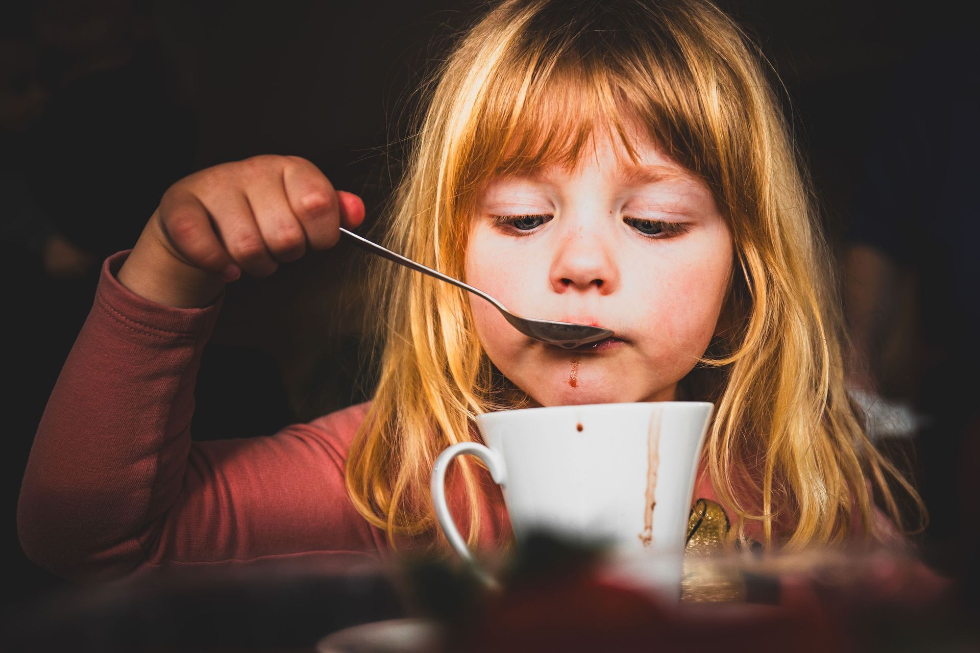 kind löffelt kakao aus der tasse - echter moment aus dem alltag, kinderfotografie im chiemgau