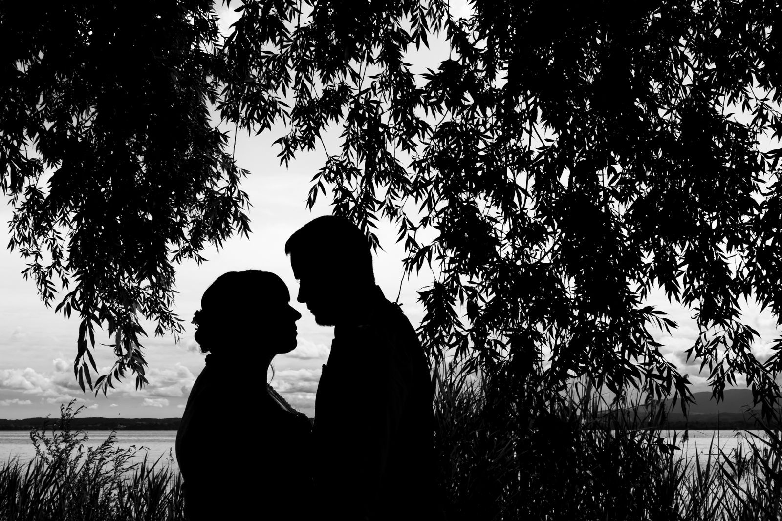 silhouette brautpaar auf fraueninsel mit chiemsee im hintergrund
