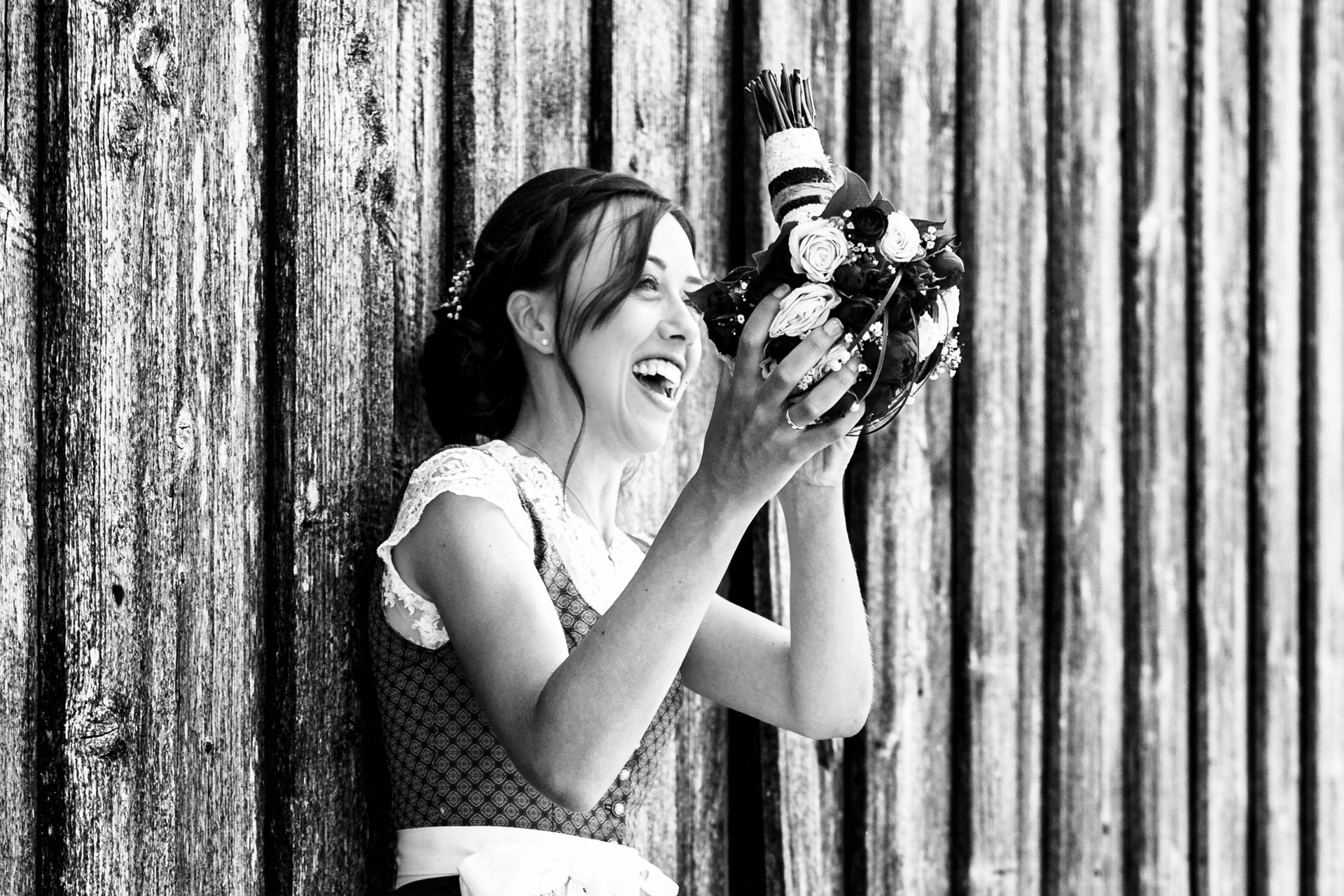 braut in tracht fängt brautstrauß