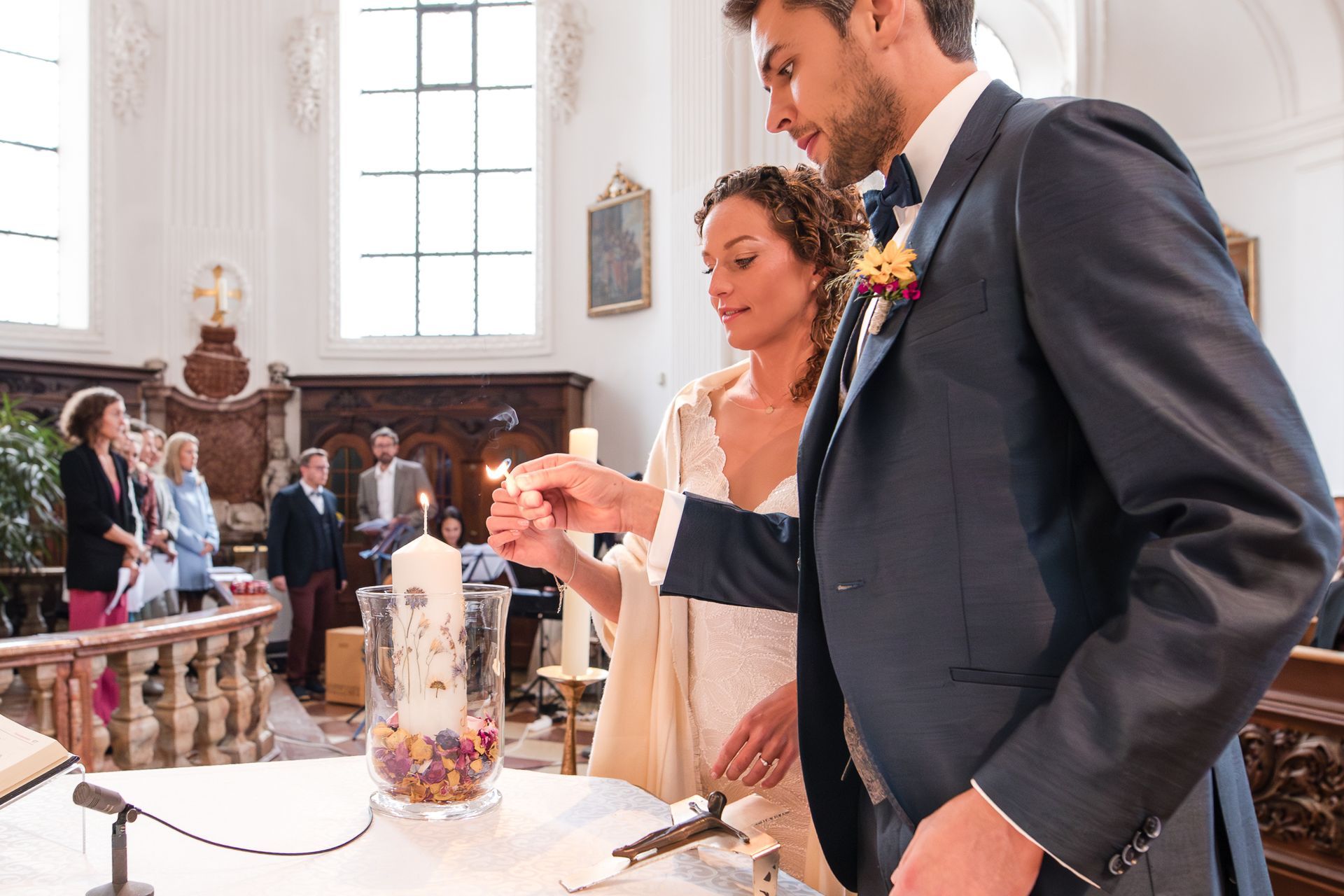 brautpaar entzündet kerze bei hochzeit in einer kirche im chiemgau