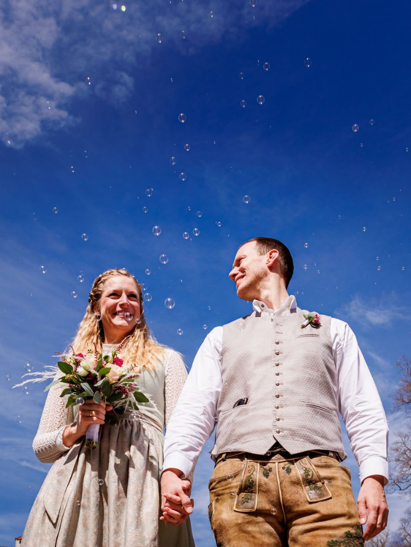 Die Braut wartet auf den Zustieg zum Schiff // Heiraten auf der Fraueninsel, Andrea Kühl 2023 braut in tracht und blumen in der hand steht auf holzsteg