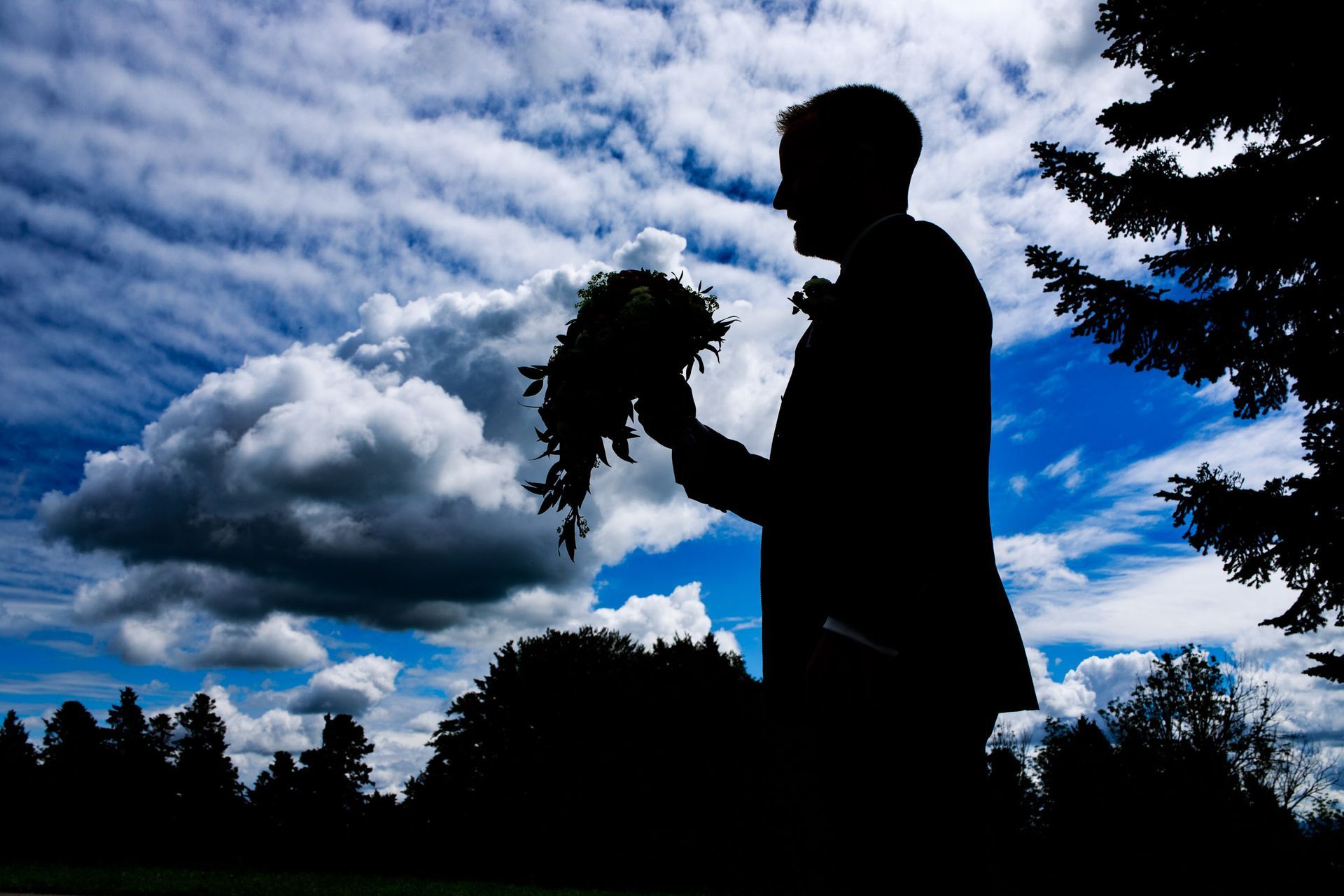 hochzeitsbilder hochberg chiemgau braeutigam mit brautstrauß silhouette
