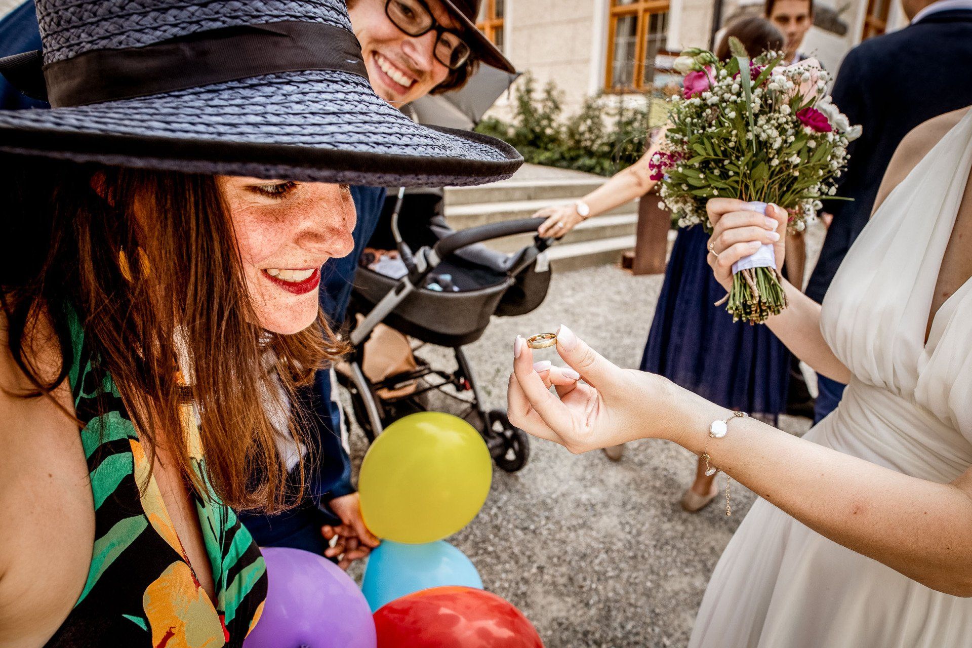 hochzeitsbilder momentaufnahmen braut zeigt ihren ring einer frau mit hut