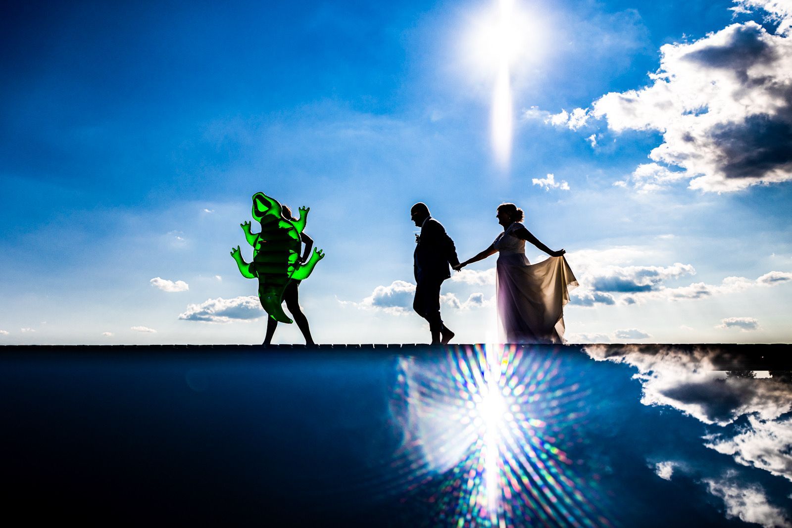 hochzeitspaar silhouette läuft person mit gründem badekrokodil hinterher