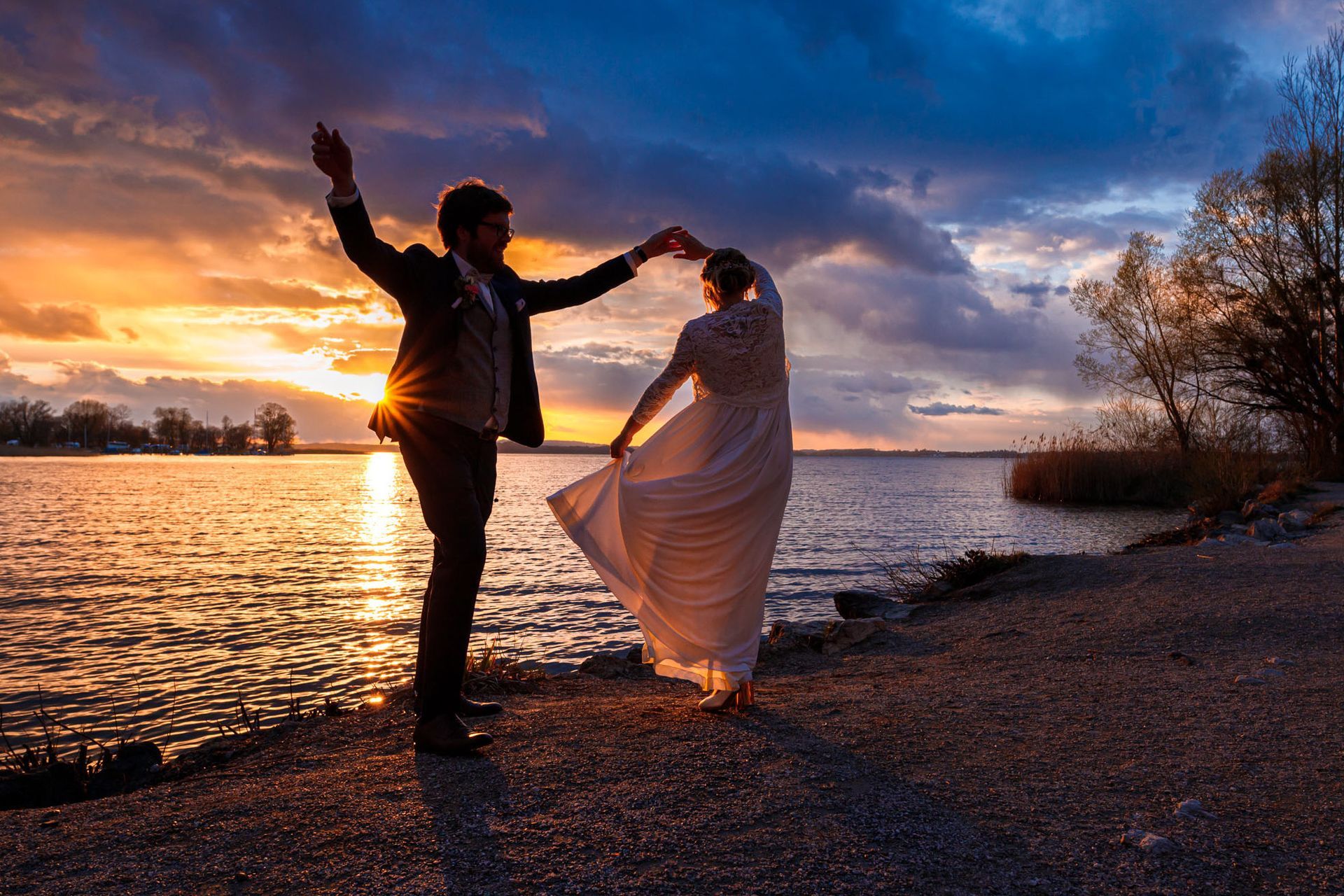 Brautpaar tanzt am Chiemsee in sonnenuntergang