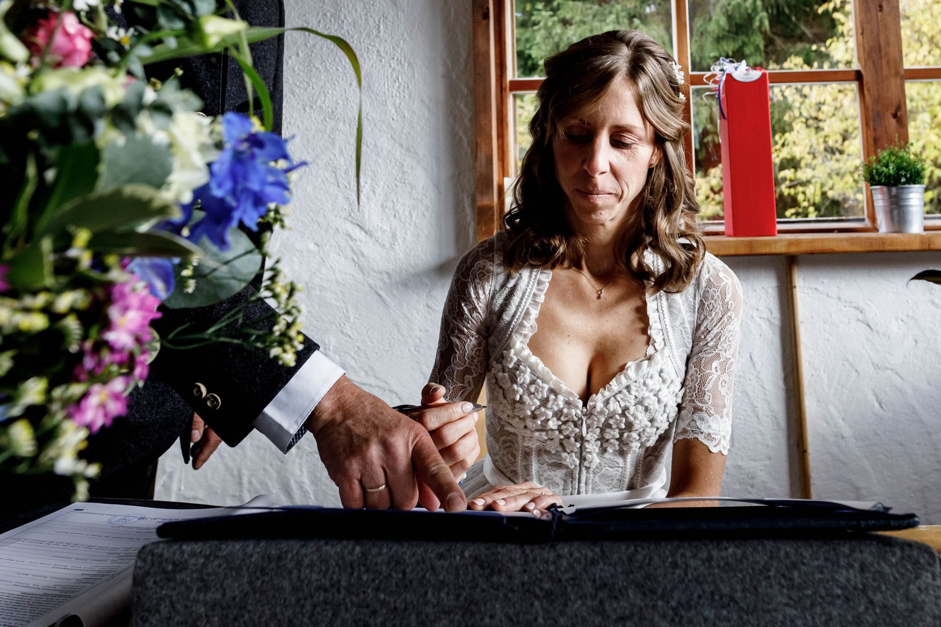 männliche hand zeigt der braut wo sie unterschreiben muss