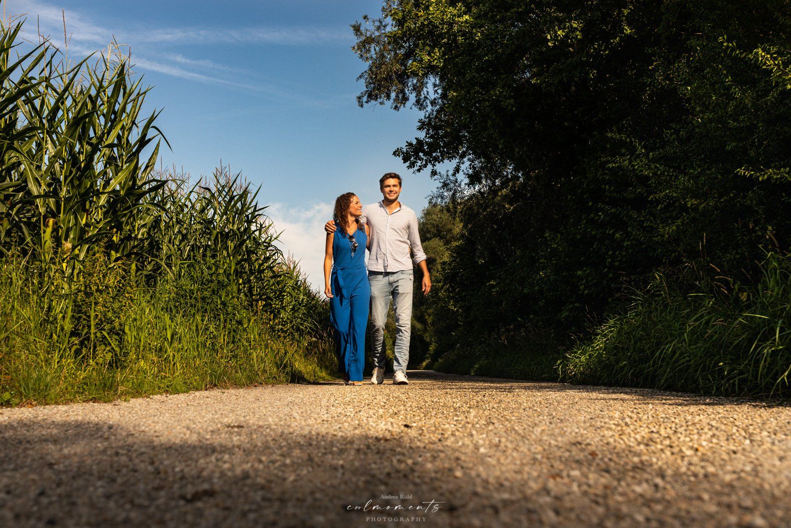 paar geht zwischen maisfeldern spazieren
