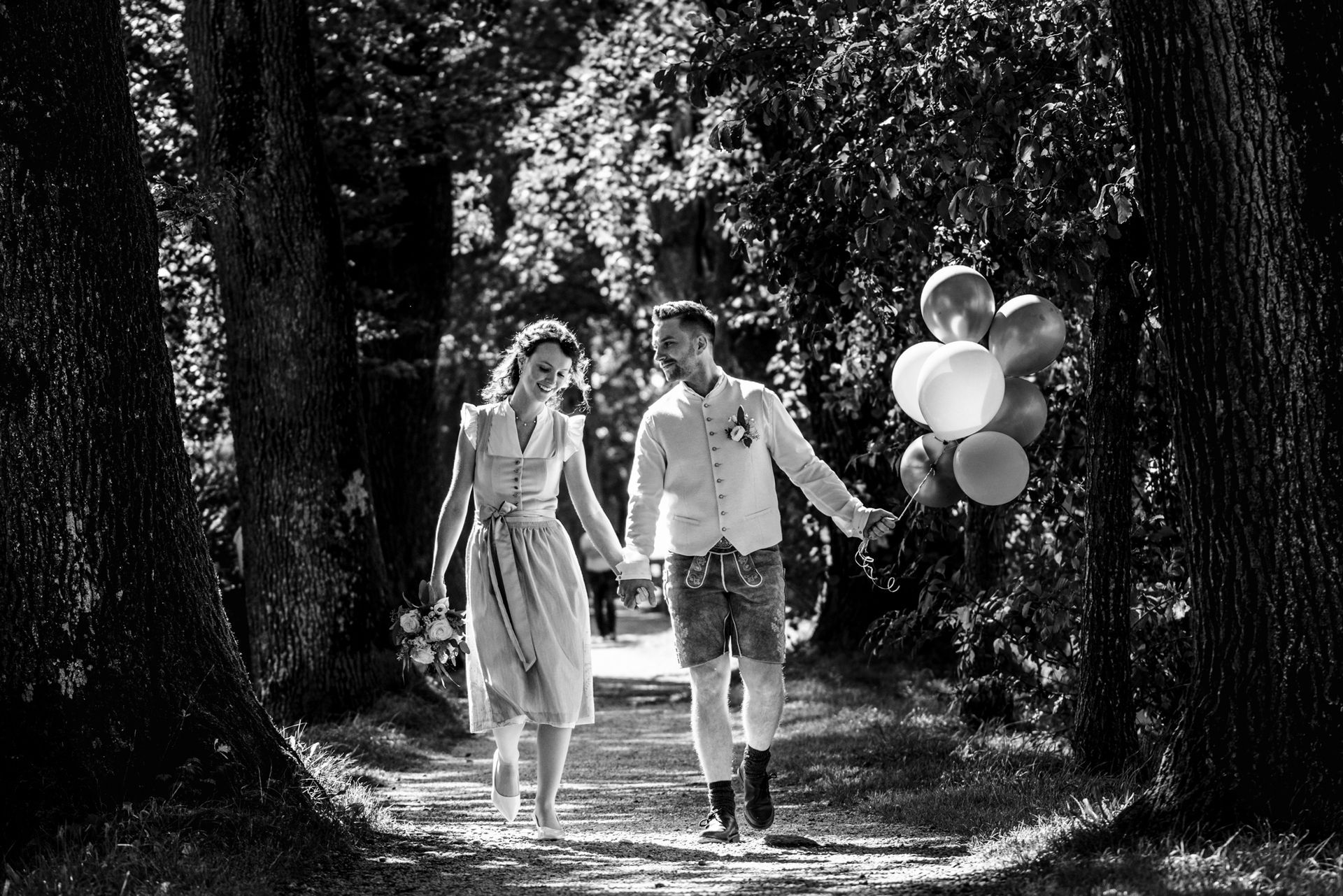 brautpaar in tracht geht im wald spazieren