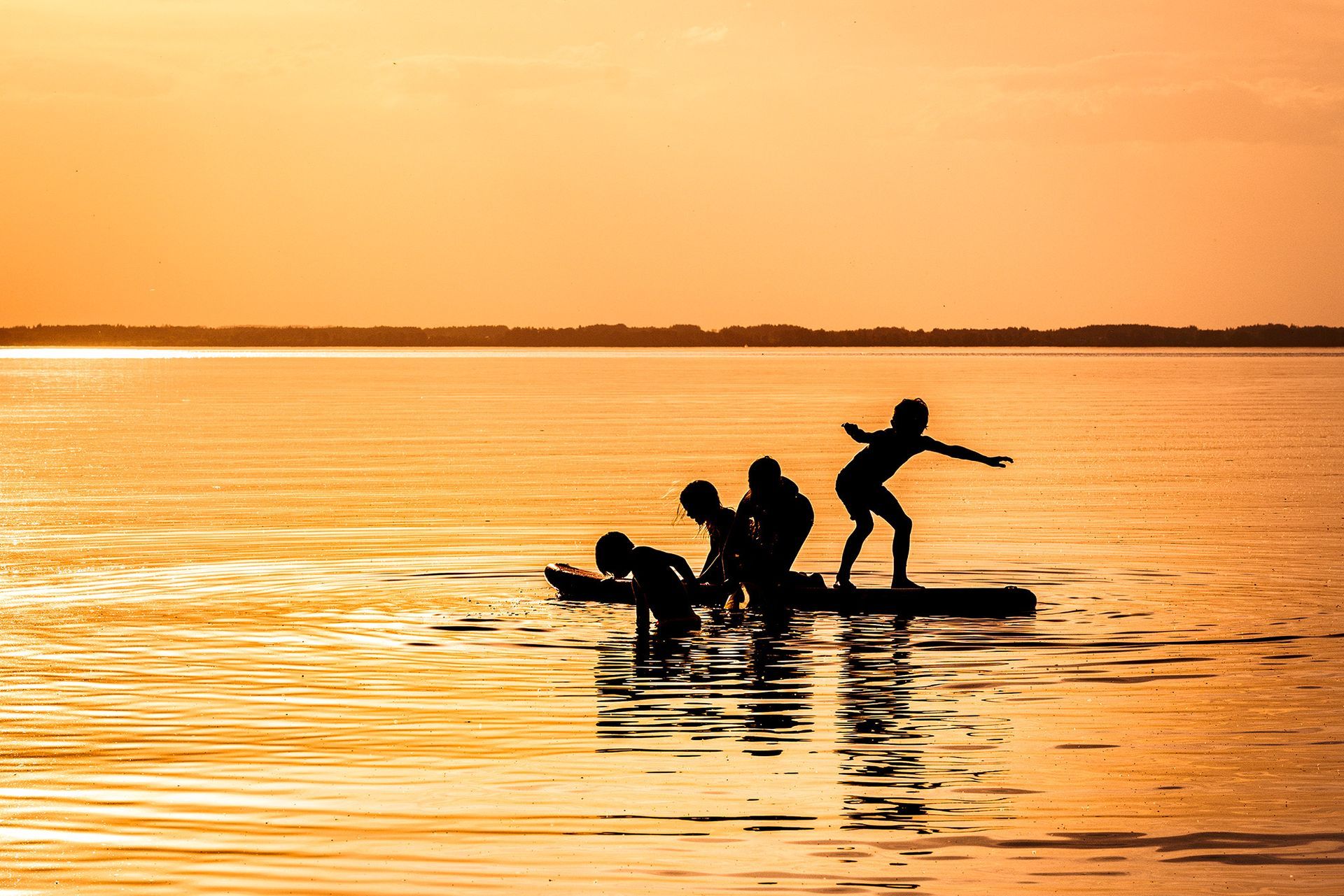 Urlaubsbild im Gegenlicht 4 kinder auf SUP im Chiemsee Urlaubsbilder
