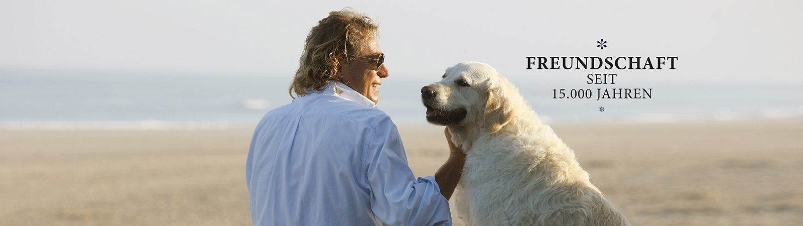 Das Bild zeigt den Geschäftsführer Frank Hertrich mit Hund Lissy