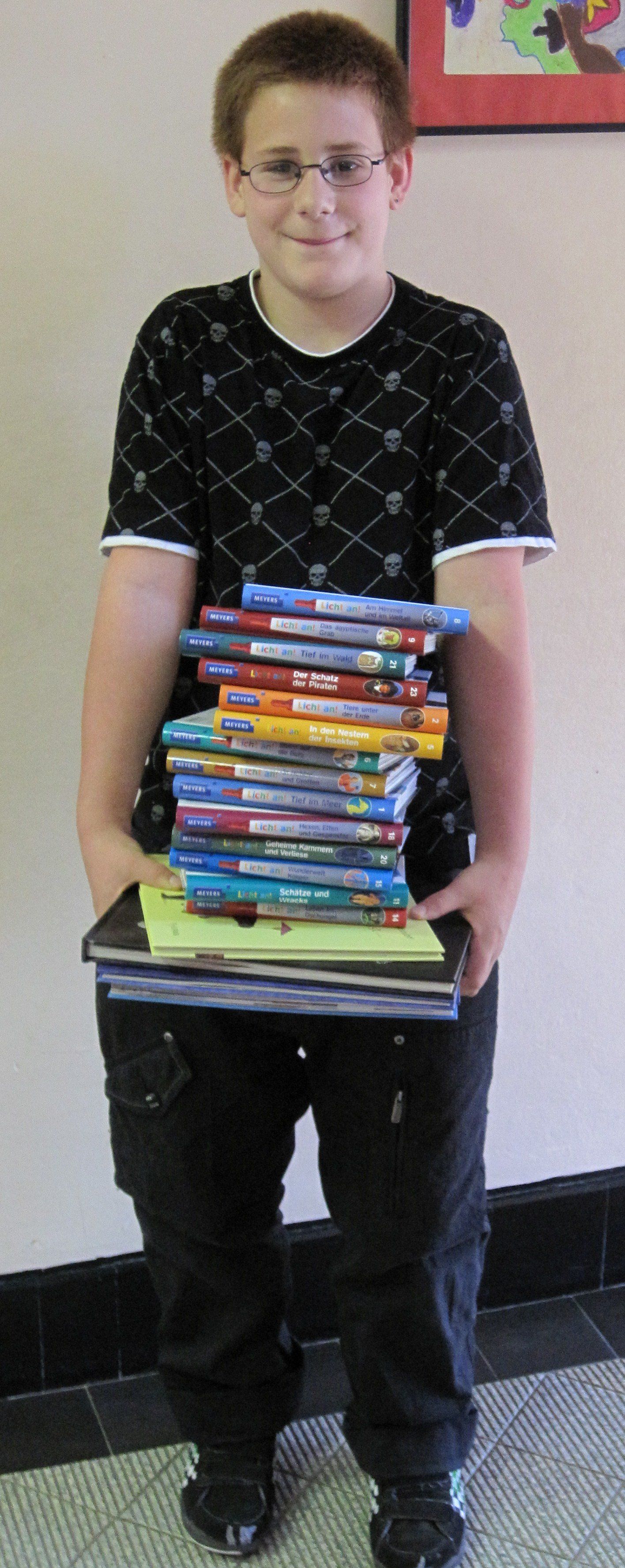 Junge trägt Bücherstapel