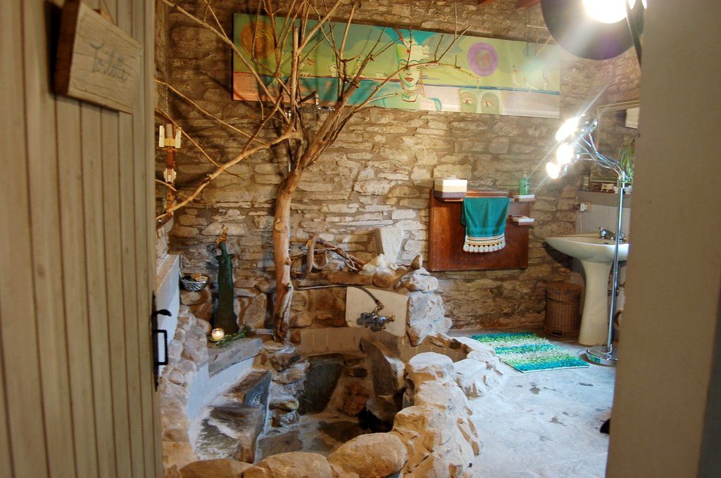 bagno di pietra con doccia e vasca e albero di sambuco